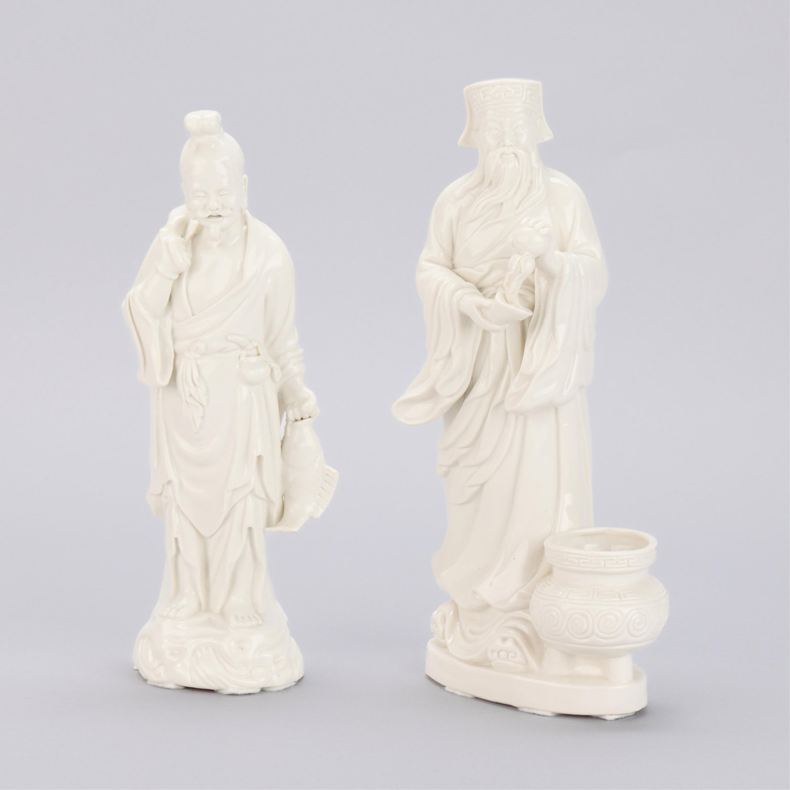 Pr Chinese PRC Blanc de Chine Porcelain Figurines: Pair of Chinese PRC Blanc de Chine porcelain figurines. Including one long-bearded scholar pouring baijiu into a drinking vessel; and one fisherman holding his large catch. Each with Mayco CL labels