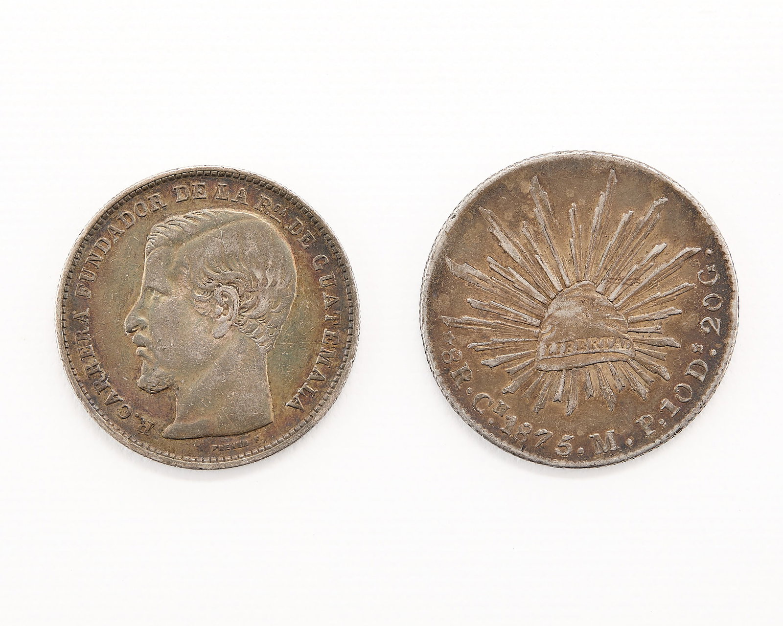 2 Silver Coins Incl. Mexican 8 Reales: Group of two fine silver coins including: one 1875 Mexican 8 reales coin; one 1868 Honduran un peso coin. (Reales) diameter: 38.75 mm. Weight: 27.21 g. (Peso) diameter: 37.17 mm. Weight: 24.51 g.