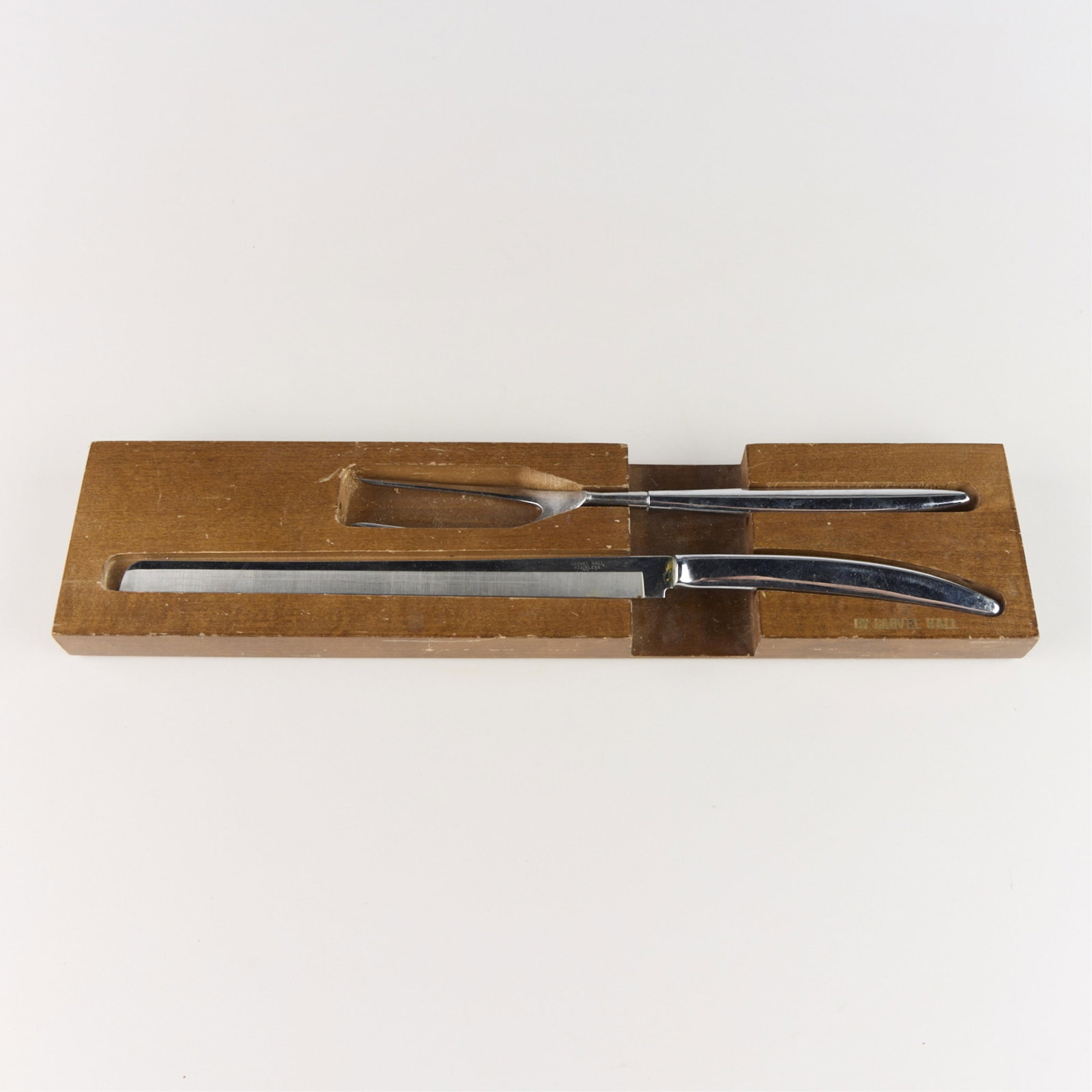 Carvell Hall Stainless Steel Carving Set: Carvell Hall stainless steel carving set with pronged fork, carving knife, and custom Carvell Hall wooden case. Each marked. (Box) Height: 1 in x width: 17 1/4 in x depth: 4 in.