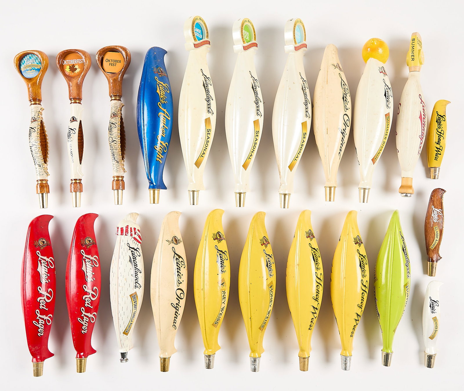 22 Leinenkugel Canoe Beer Taps: Group of 22 Leinenkugel canoe shaped beer taps including Honey Weiss, Summer Shandy, Seasonal, and more. (Shipping dimensions) height: 10 in x width: 20 in x depth: 15 in.