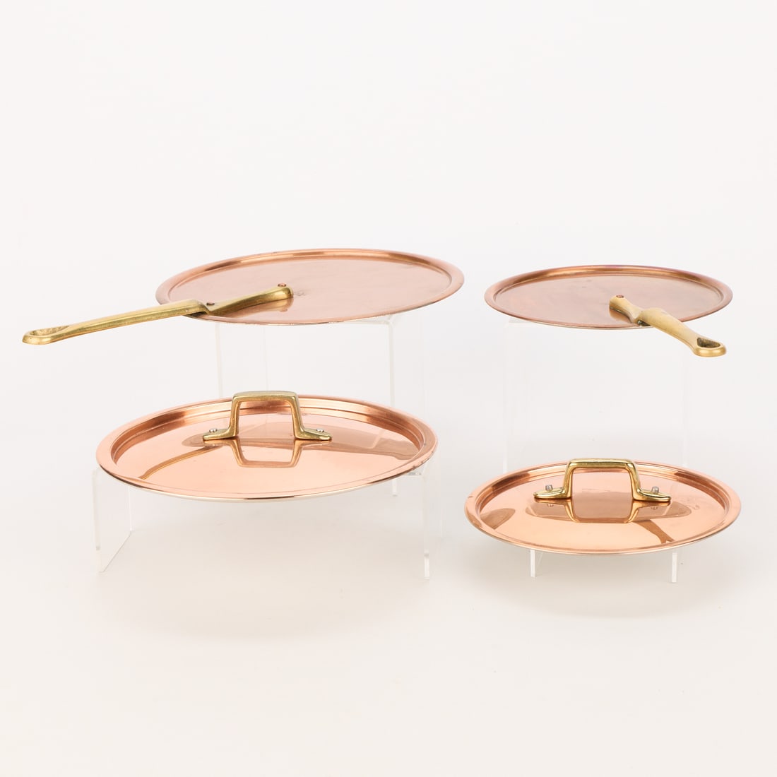 4 Copper Cookware Sauce Pan Lids: Group of four copper cookingware lids. Including two Waldow Company copper lids, marked near the handle, and two unmarked copper lids. Each with brass handles. (Largest) Width: 13 3/4 in x diameter: 9