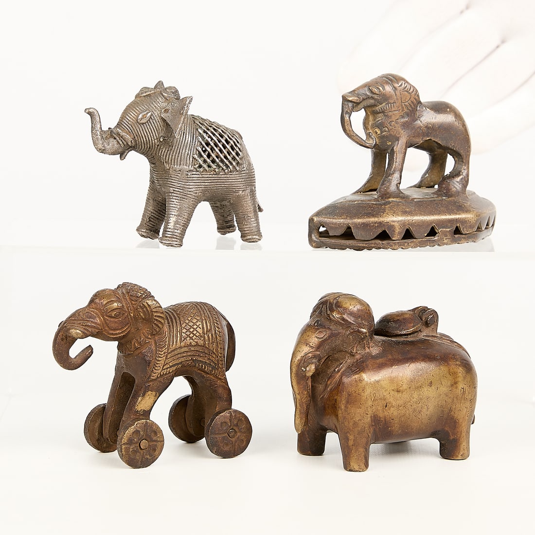 4 SE Asian & Indian Brass & Bronze Elephants: Group of four Southeast Asian and Indian brass and bronze figurines in the forms of elephants. Height ranges from 2 1/4 in to 2 1/2 in; width ranges from 1 1/4 in to 1 3/4 in; depth ranges from 2 3/4 