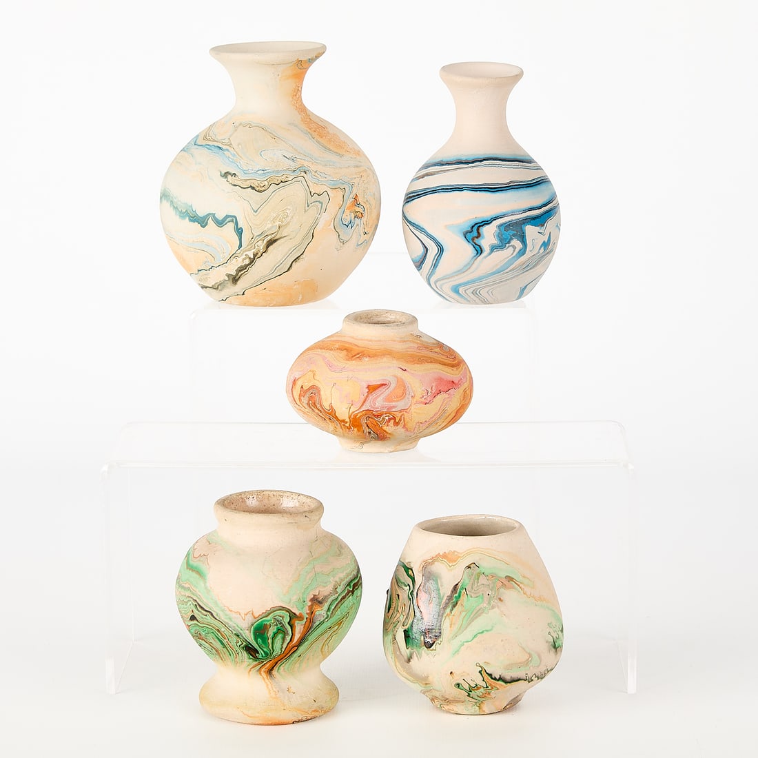 5 Nemadji Pottery Earthenware Swirl Vases: Nemadji Indian Pottery, Minnesota. Group of five earthenware bud vases with distinctive swirl motifs executed in vibrant glazes. All but one inkstamped along the underside. Height ranges from 2 1/2 in