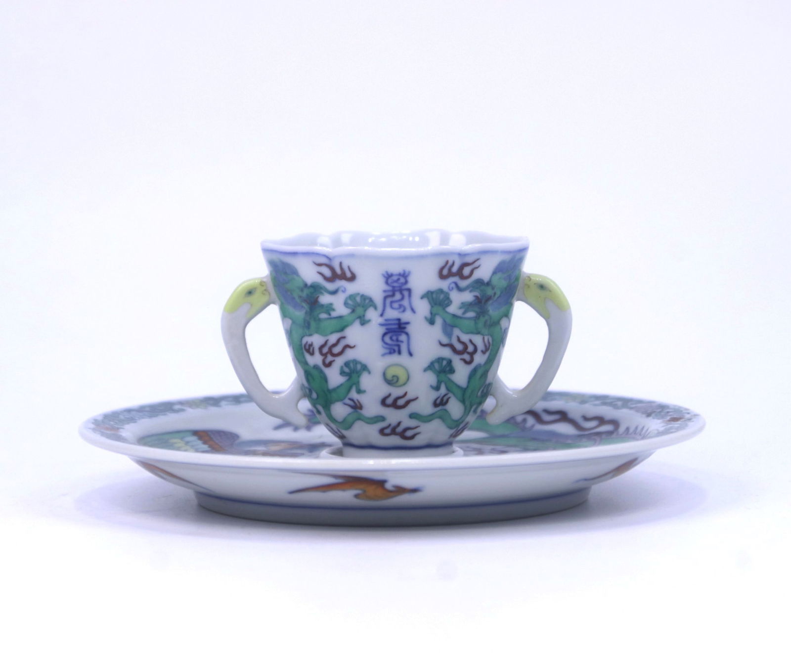 A doucai tea cup and saucer: A doucai tea cup and saucer, with dragons and bats