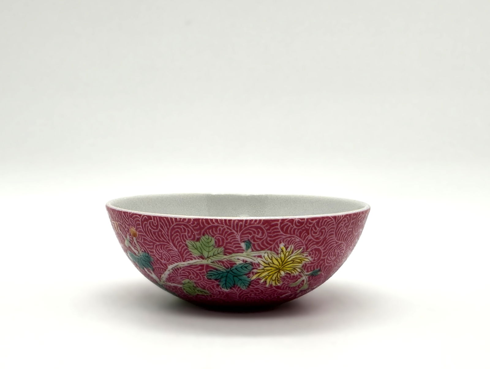 Chinese Famille Rose Sgraffiato Floral Bowl,19th.C: This vibrant bowl from the Daoguang reign (1821–1850) features a striking pink ground with a fine incised "sgraffiato" pattern, overlaid with famille rose painted chrysanthemums and other flowers. T