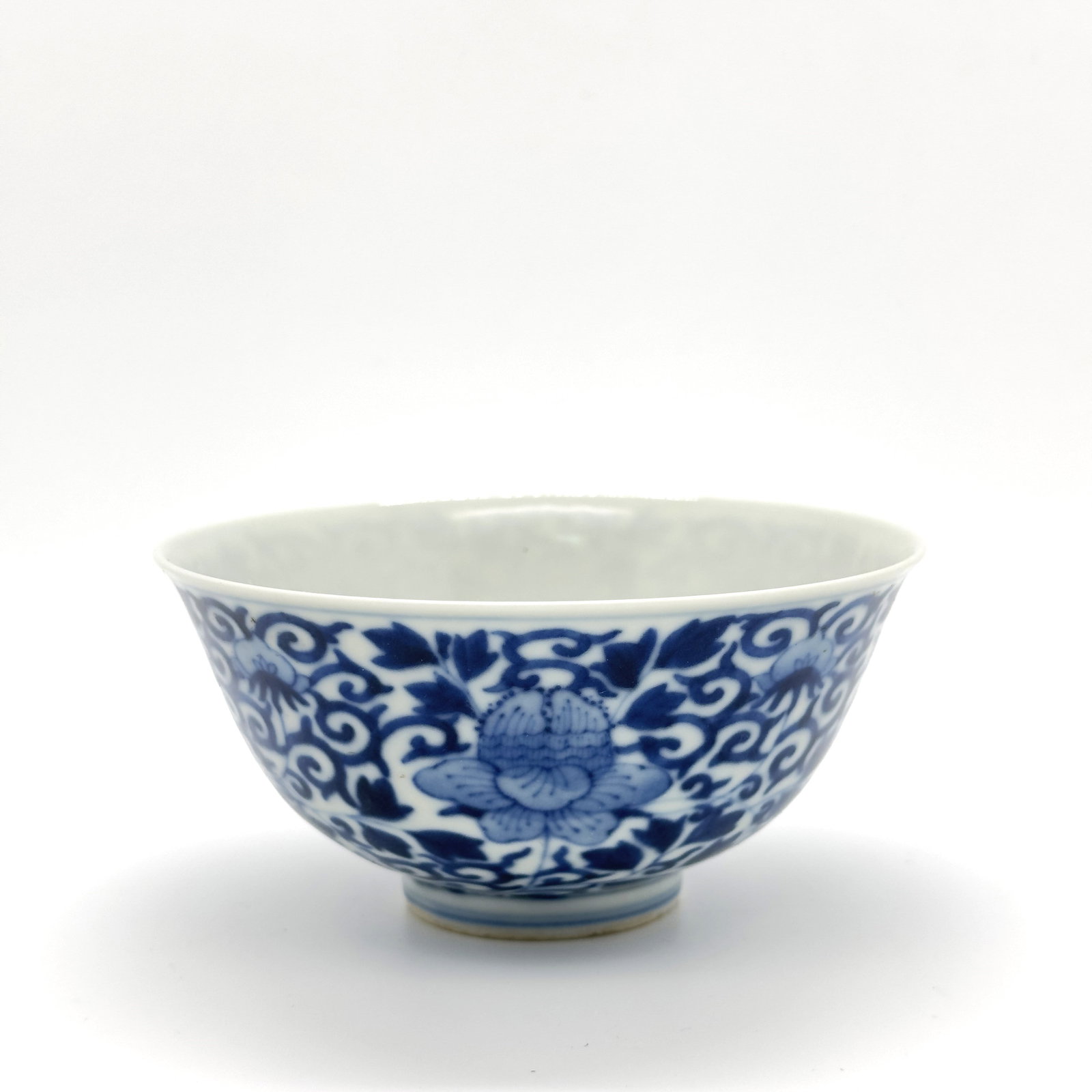 Blue and White Continuous Floral Scroll Bowl ? 19TH.C: A finely potted antique Chinese blue and white bowl, intricately decorated with a continuous scrolling design of lush peony or lotus flowers and foliage, typical of classic porcelain motifs.Diameter:4