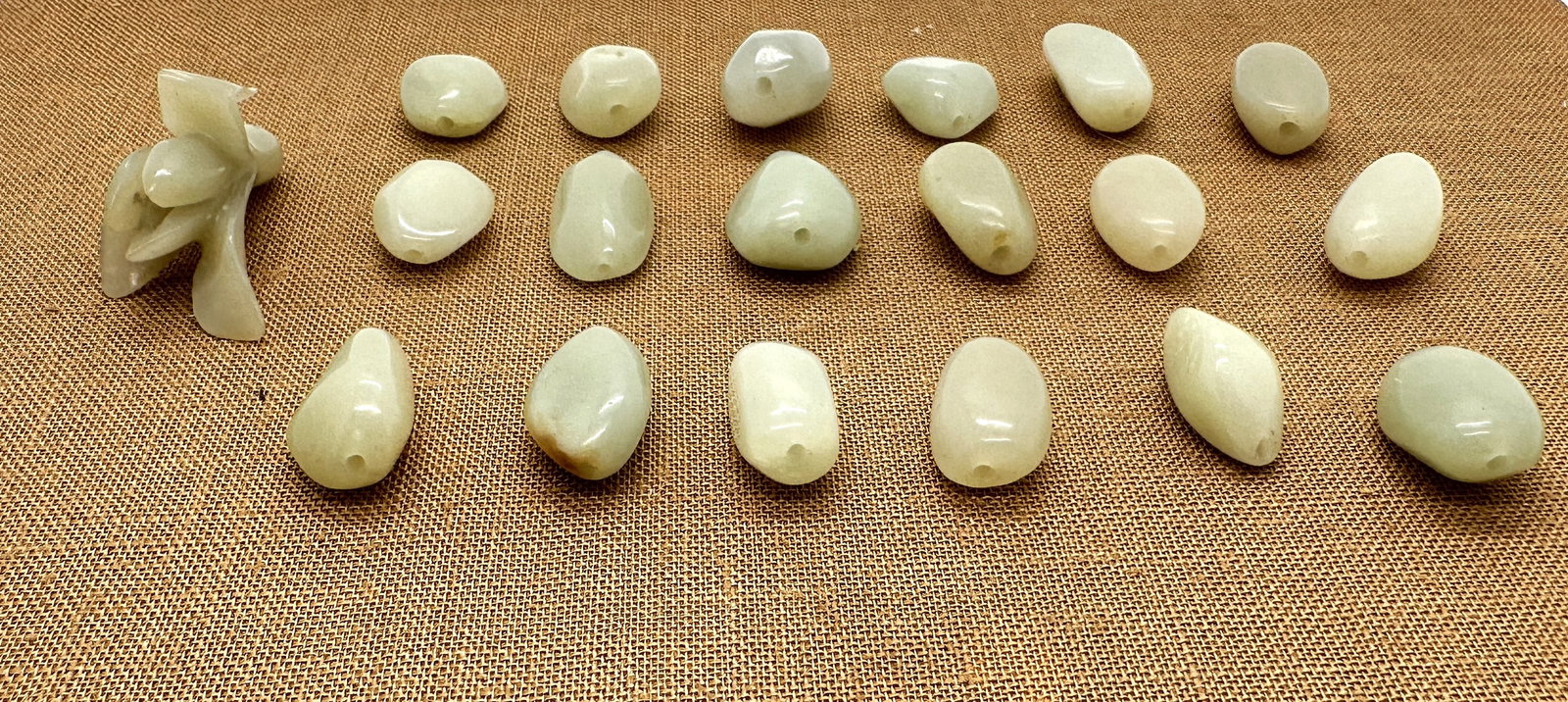 Group of Chinese White Jade Beads and Carved Pendant.19th.C: A group of Chinese white jade beads and a carved pendant. The irregular, free-form beads are drilled for stringing, while the pendant is carved as a delicate flower. All are crafted from pale, translu