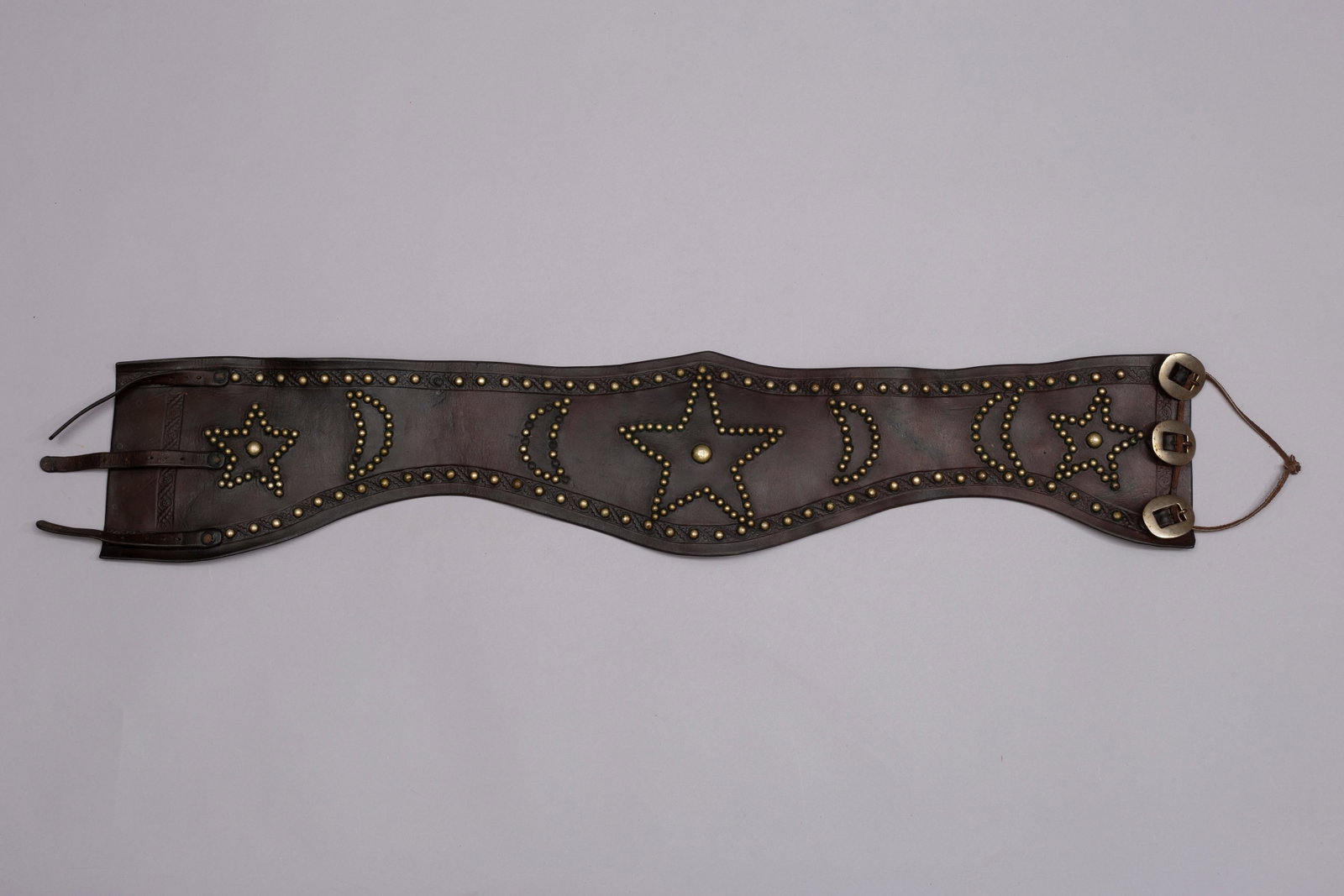Vintage Cowboy Bronc Belt, Ca. 1920s-40s: Vintage Cowboy Bronc Belt, Ca. 1920s-40s. Belt is designed with tacked stars and half-moon pattern, three silver buckles and tooled edges.Measurements: 34"L x 7"W