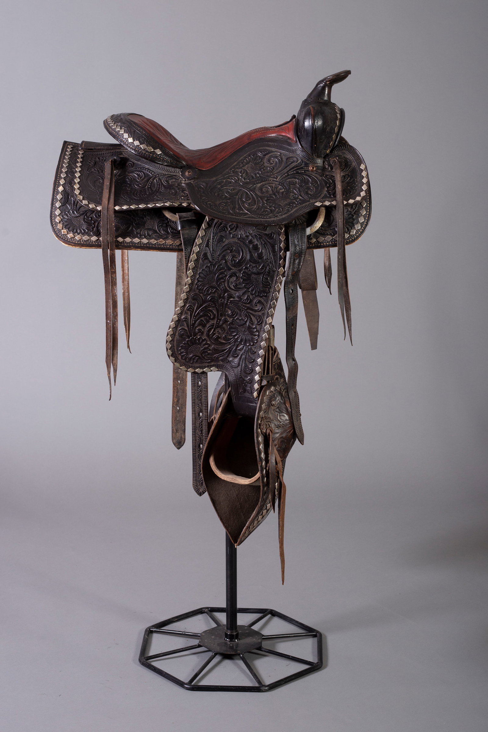 Black Fully Tooled Saddle with Red Seat, Ca. 1960s: Fully tooled with silver diamonds, and tapaderos, Stamped "840", Ca. 1960s. Please note, stand not included.