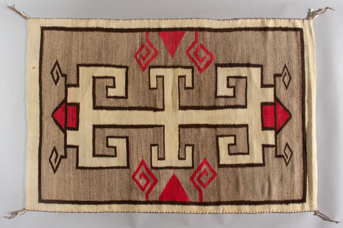 Navajo Rug, Ca. 1915-1925: Bold designed antique Navajo rug with interesting red and black spiral motifs surrounding a large, hooked medallion on a field hand-carded, variegated grayish brown, Ca. 1915-1925. Hand woven from all