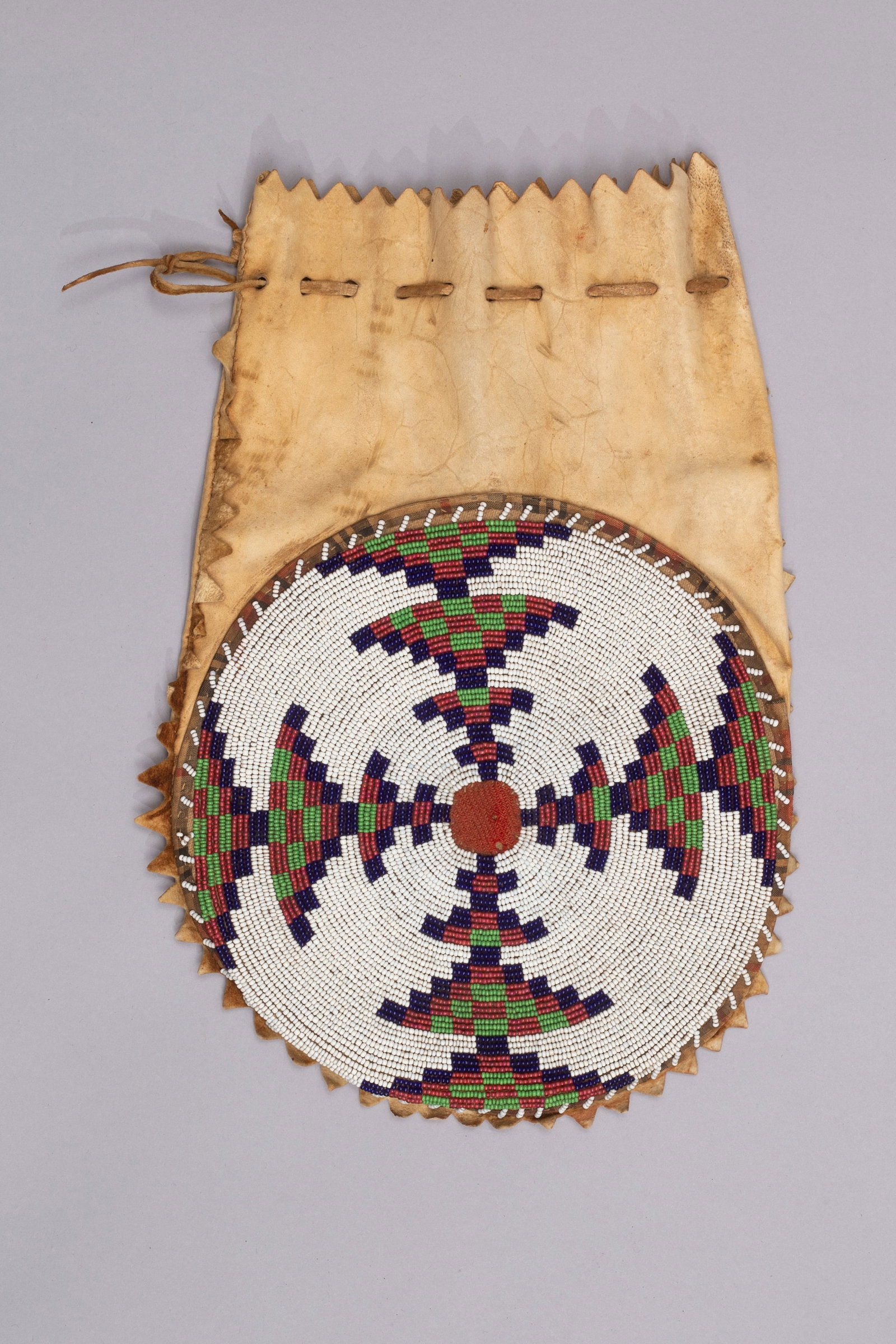 Blackfoot Bag with Large Rondel, 19th Century: Blackfoot bag of hide with large, beaded rondel, 19th Century, Measurements: 12" x 8"