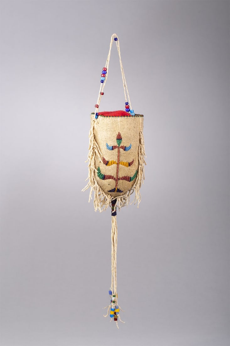 Santee Sioux Three Sided Beaded Bag: Santee Sioux three sided beaded bag. Sinew sewn on brain tanned doe skin. Beaded on three sides in red, navy, green, and yellow. Measurements: Bag 6", Total length with fringe: 15"