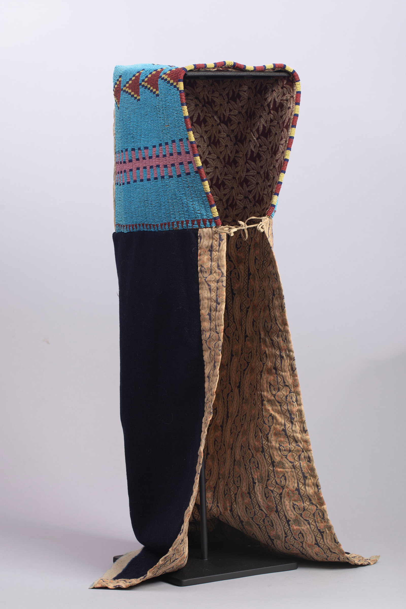 Sioux Beaded Soft Cradle, Ca. 1890s: Sioux Beaded Soft Cradle, Ca. 1890s. Multi-color beaded Sioux soft cradle featuring beaded top on hide with navy blue trade wool bottom, lined and trimmed with early period trade cloth. Top of hood is