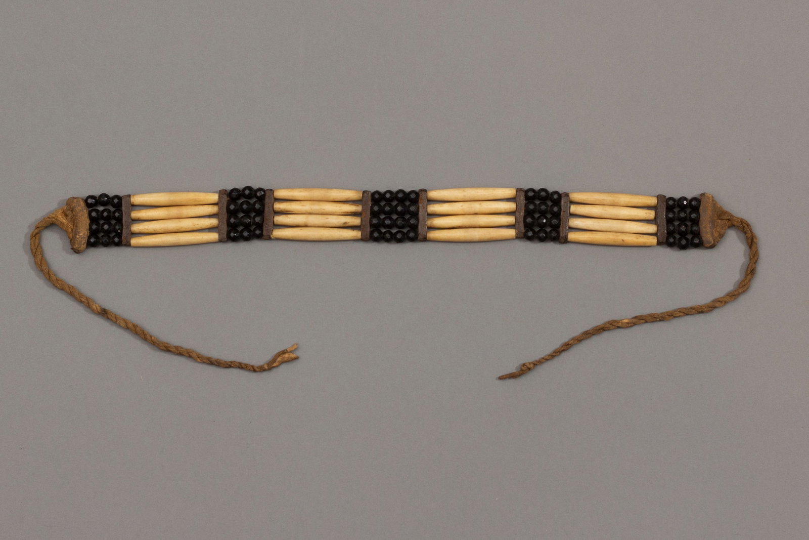 Early Native American Bone Choker Necklace: Four rows of bone with alternating onyx beads and leather spacers, attached by old leather twisted ties. Beaded section: 13 1/2", Total length with twisted ties 31 1/2"