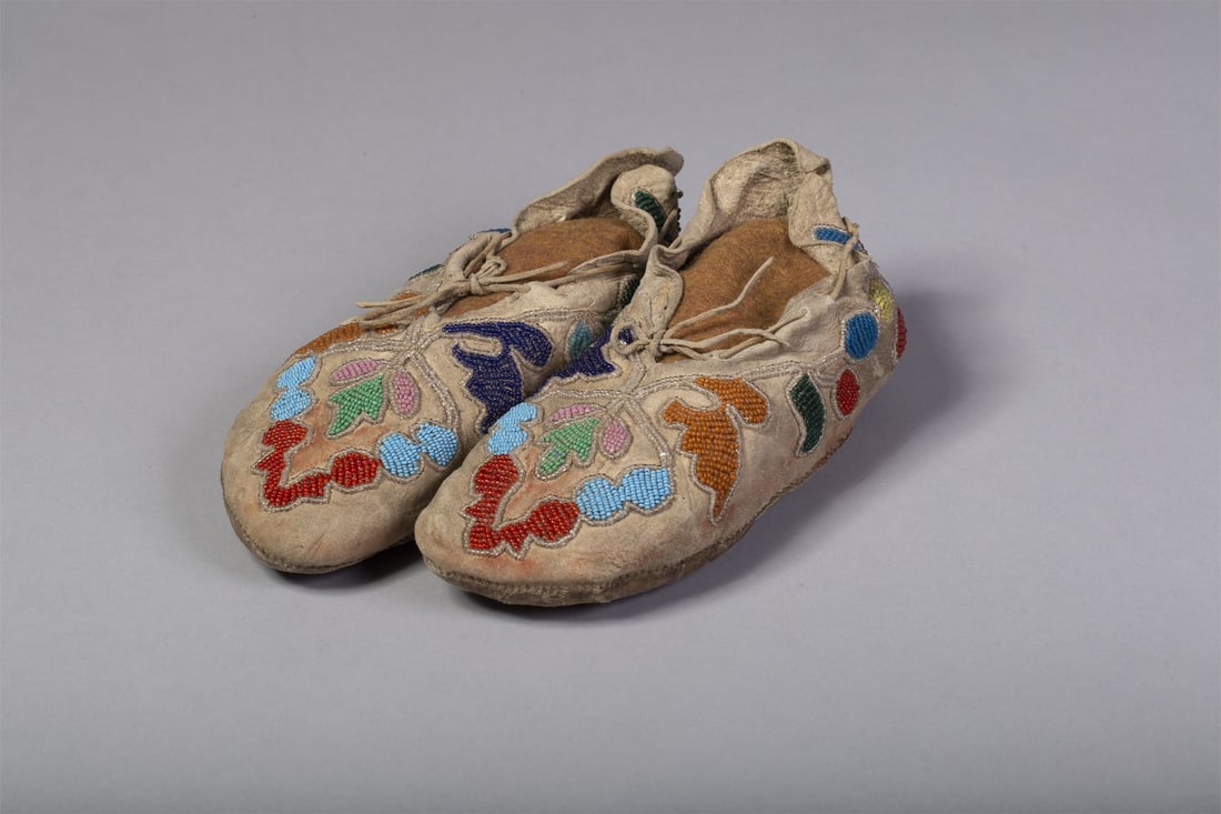 Santee Sioux Floral-Designed Beaded Moccasins: Santee Sioux Floral-designed beaded moccasins. Thread and sinew-sewn with a floral design in brown, pink, blue, navy, green, yellow and outlined in clear beads. Measurements: 9 1/2"L