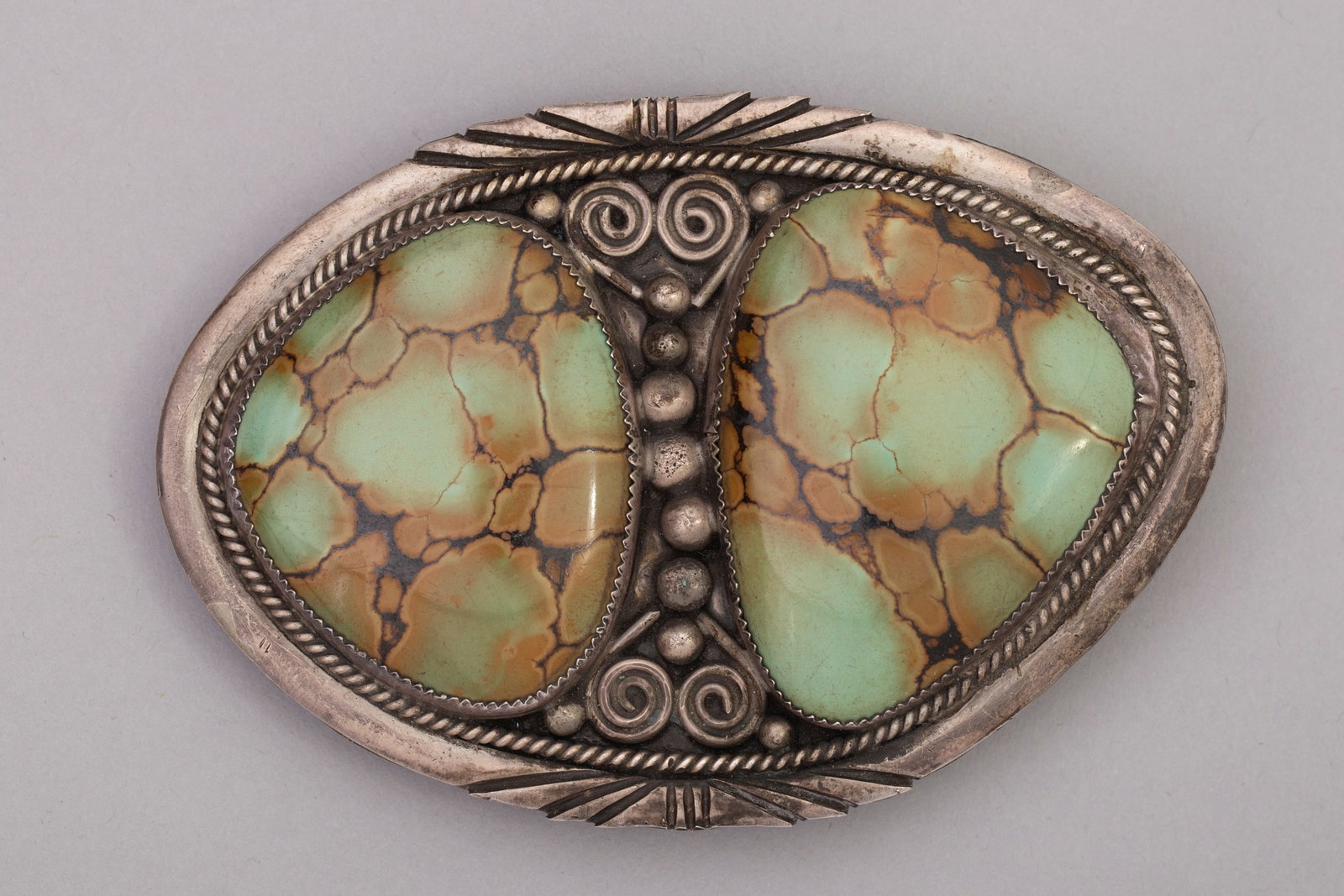 Garrison Bory, Butterfly Design Silver & Green Turquoise Belt Buckle: Silver belt buckle with 2 green turquoise stones set as wings of a butterfly and silver work designed as the abdomen and antennae hallmarked "G", Garrison Bory. Buckle: 4" x 3", stone 1: 1 3/4" x 1 1/
