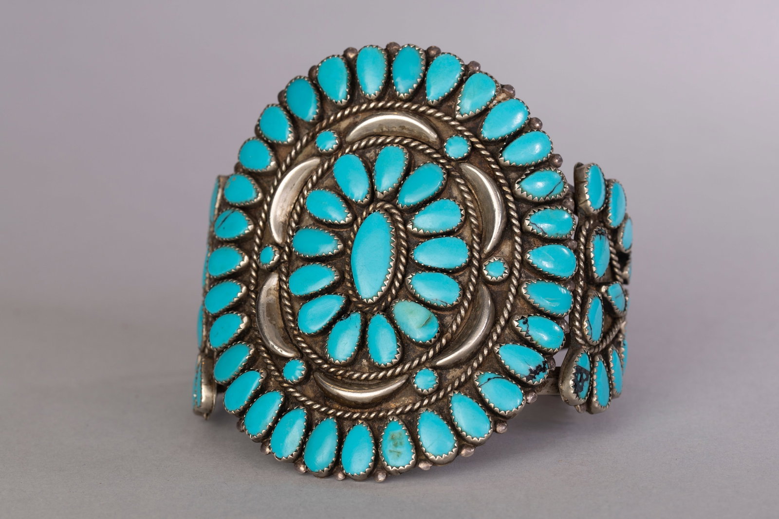 Large Zuni Cuff: Large Zuni cuff in wagon wheel design. Internal circumference: 6 1/4", Gap: 1 1/2", Width: 3 1/2", Weight: 105 grams.