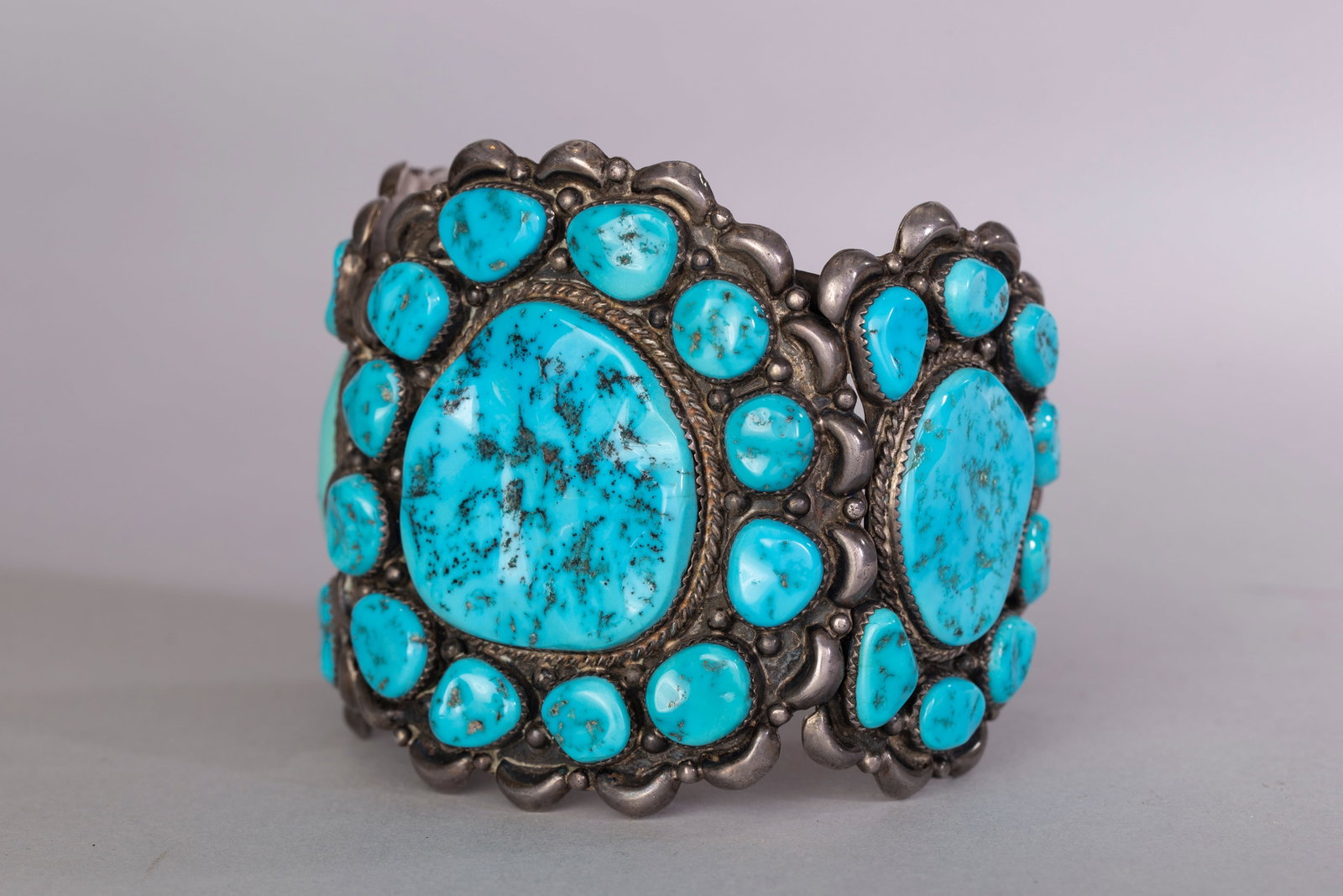 Ben Touchine, Large Turquoise Bracelet: Large turquoise bracelet handcrafted and signed by award winning Navajo silversmith Ben Touchine. Bracelet contains 3 large turquoise stones each surrounded with smaller turquoise stones 12 around the
