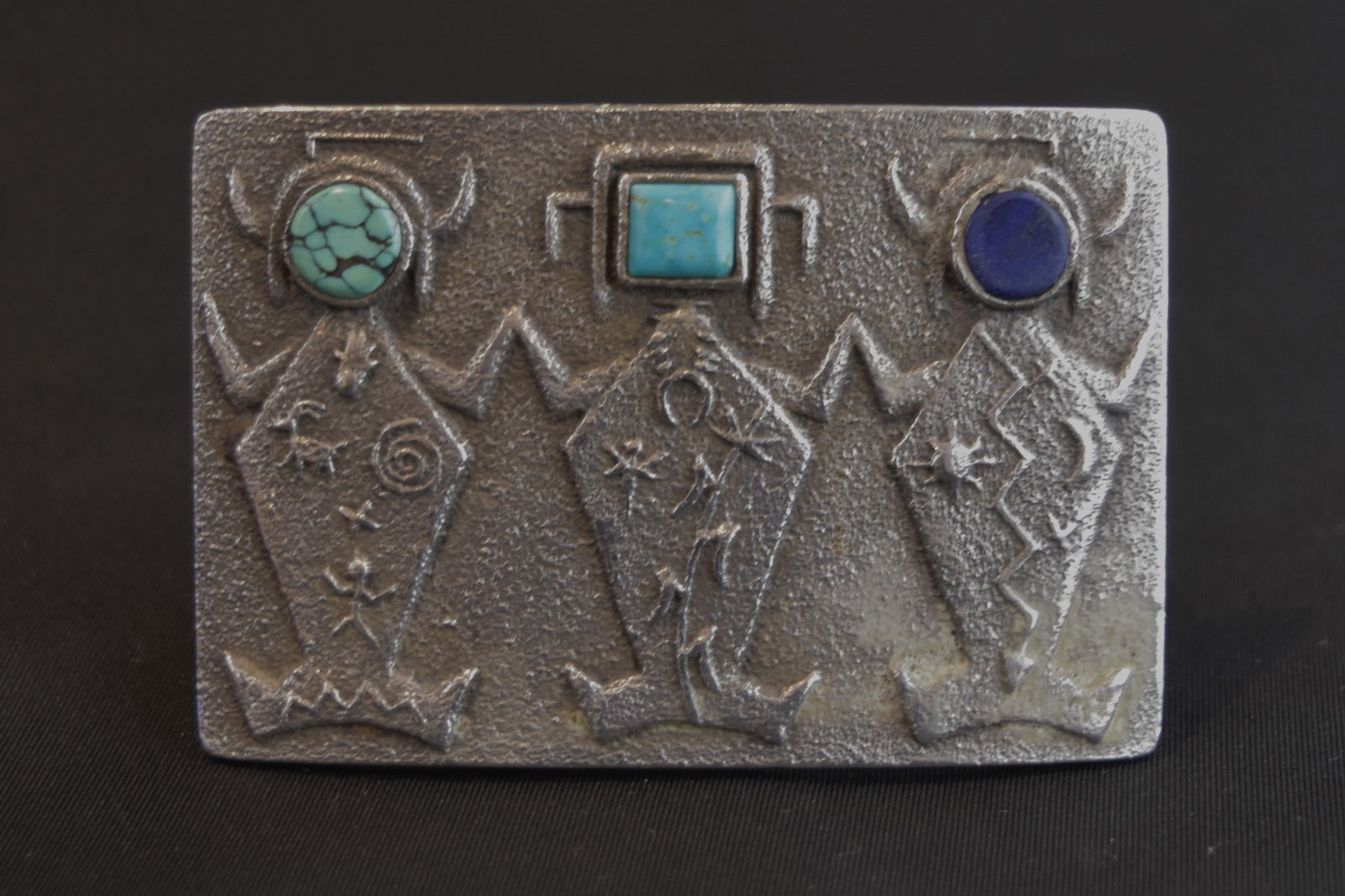 Sterling Silver Buckle with 3 Yeis With Stone Faces, Marked Lee B. for Leander Begay: Kingman turquoise, lapis lazuli, and Morenci turquoise. Their bodies feature petroglyph symbols: spiral, hand, dragonfly, corn, sun, moon, and lightning. By award-winning Leander Begay, brother of the