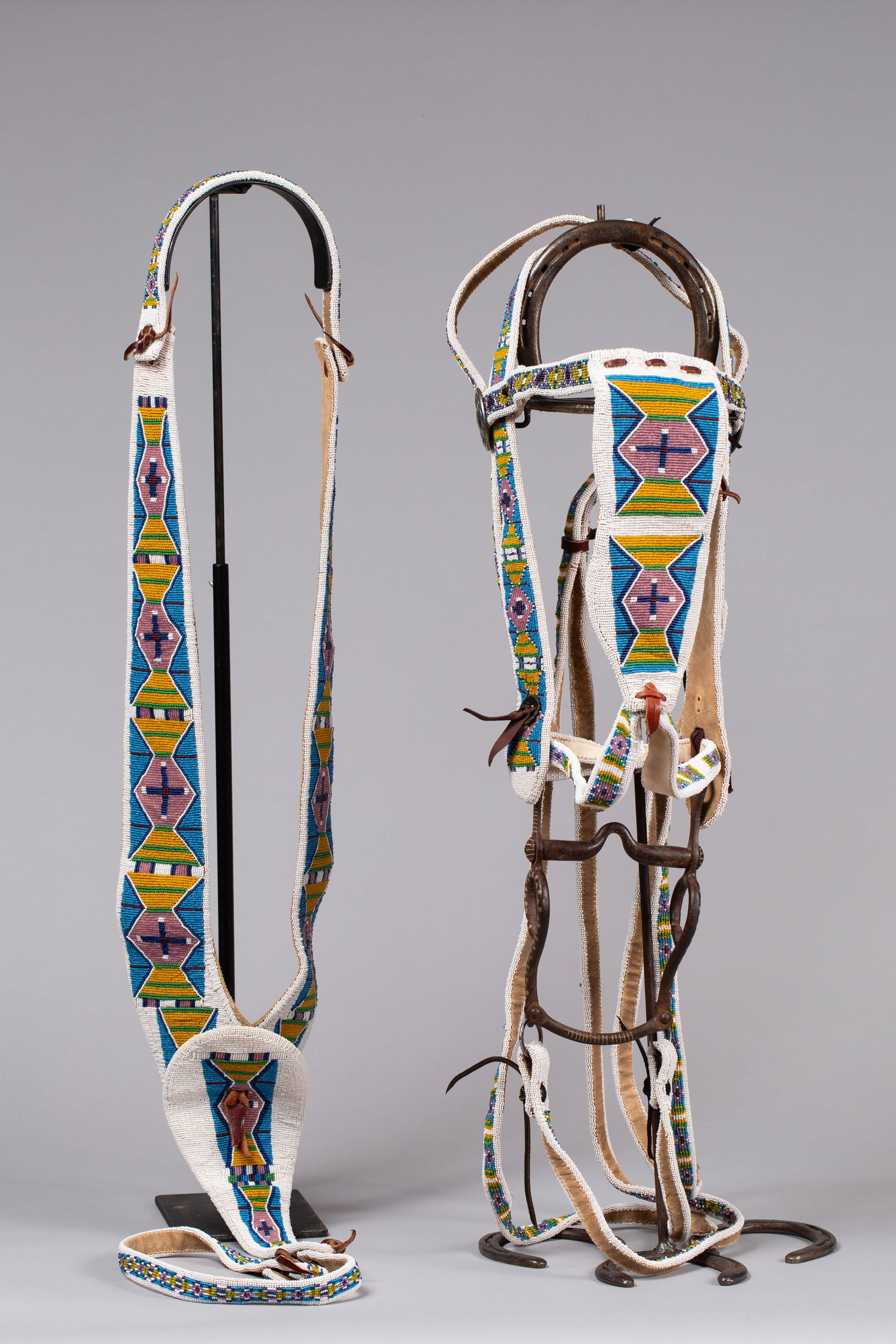 Rare Sioux fully beaded Headstall with beaded Martingale and Reins: Beaded on leather with glass beads, white beaded background with geometric shapes, beading in blue, purple, brown, green, red and yellow with silver engraved rosettes and a Mexican bit, reins are full