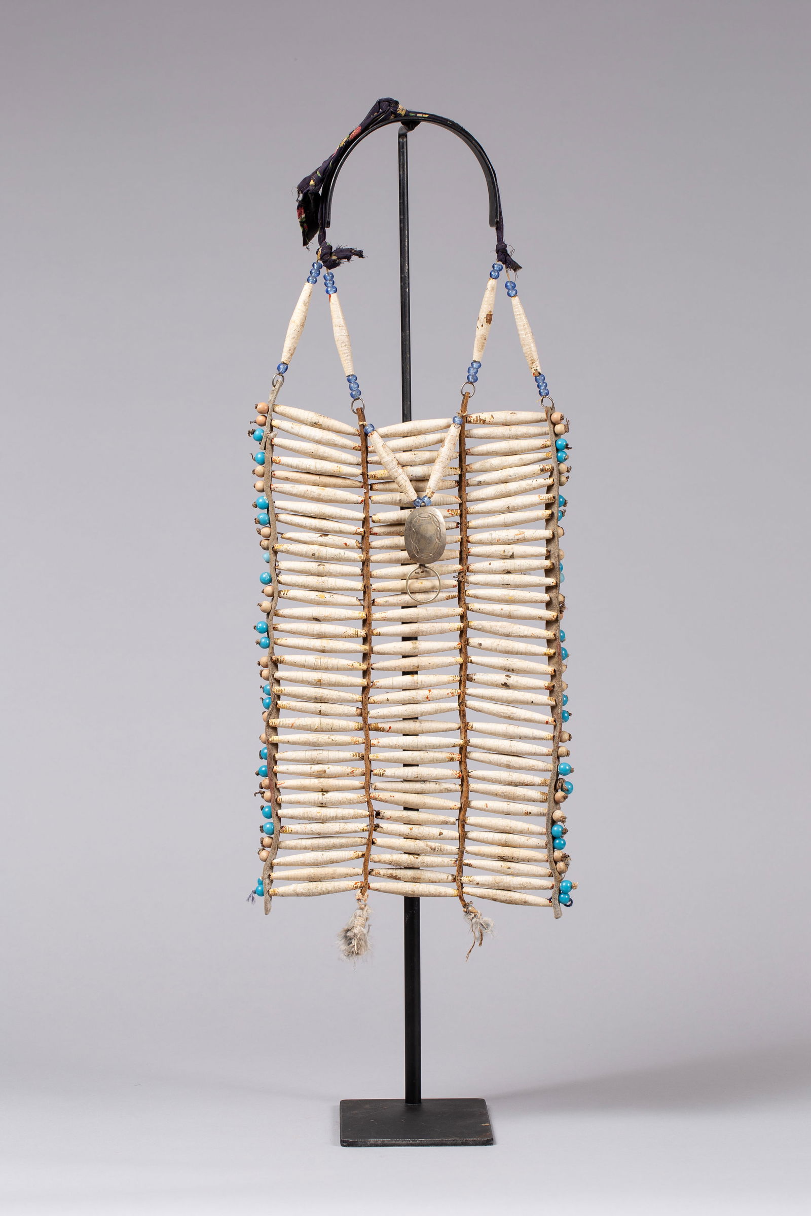 Rare Plains Breastplate: Thick leather spacers and beaded trim with silver engraved medallion, trade cloth and two feather drops. Hairpipes made of whittled wood, wrapped and painted white. Traces of red paint still exist. Ca