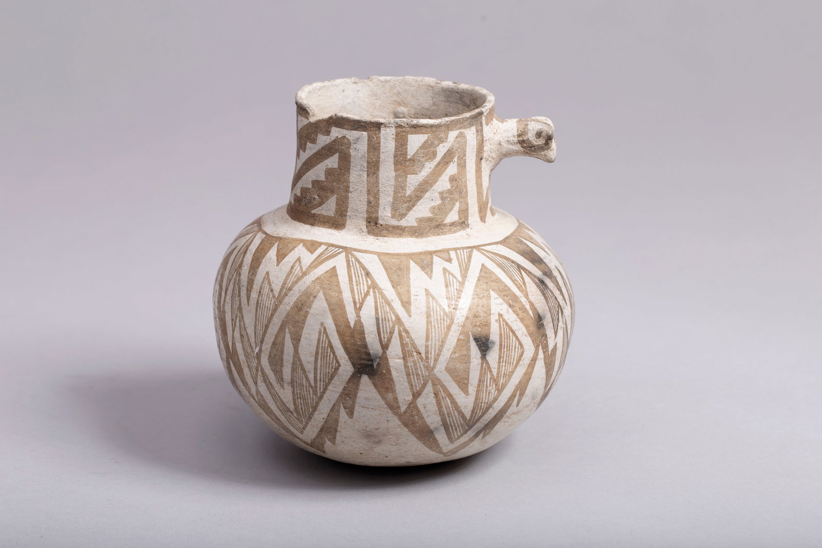 Anasazi Tularosa Pottery Jar in Deer Head design: Ancestral Puebloan (Anasazi), Tularosa type, ca. 875 to 1050 CE. The exterior is adorned with black on white geometric motifs. Measurements: 5 1/2"h x 5 1/2"d, opening 2 3/4"d