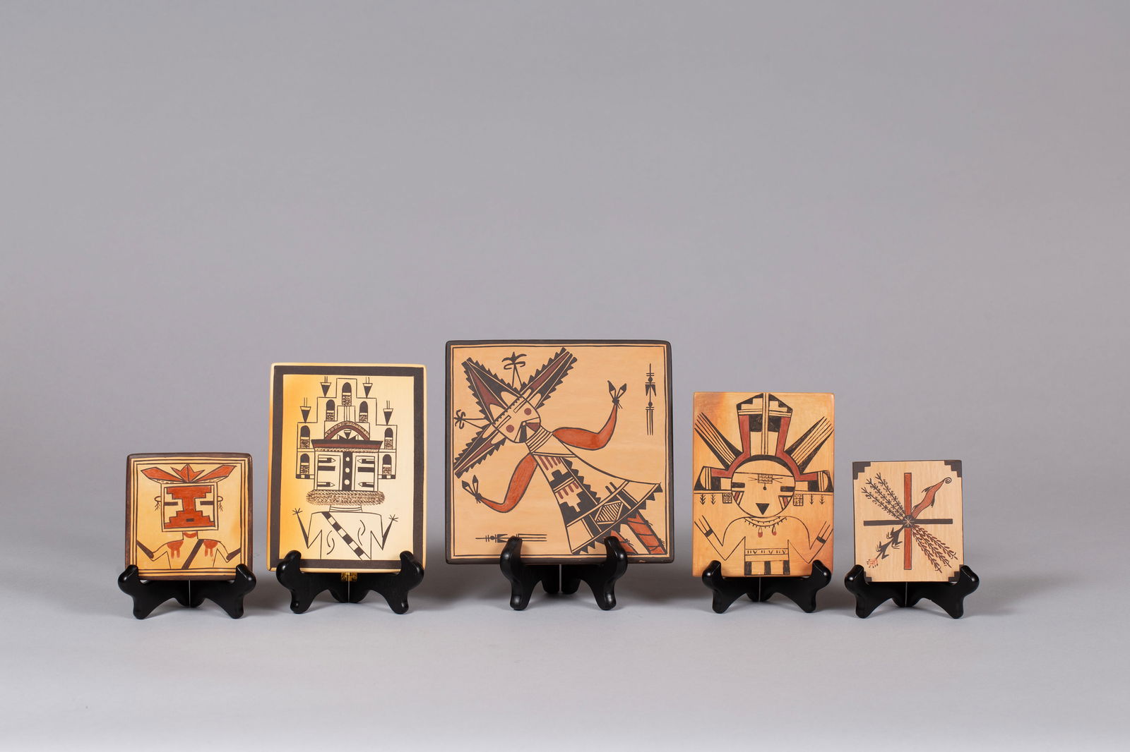Lot of 5 Hopi Tiles with Kachina Figures: Four depict Kachina figures with elaborate headdresses. The fifth represents the four directions with sacred corn plants. Tiles range from 3 3/4 x 3 1/4" to 7 x 7", 2.76 pounds altogether
