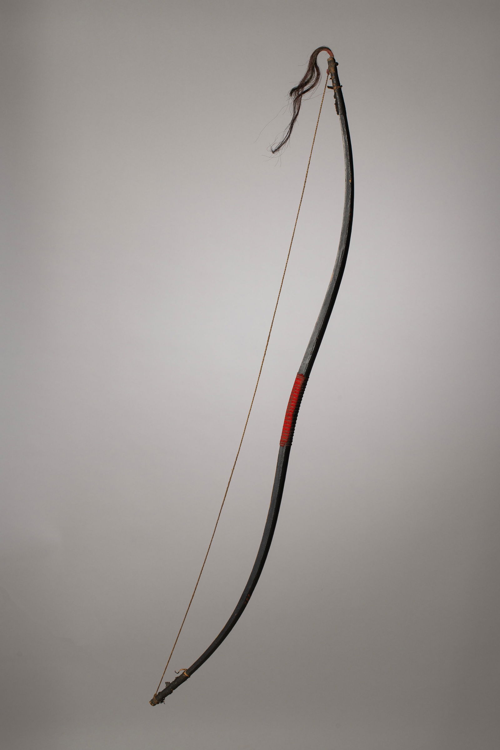 Lakota Bow and Arrow set in the Style of Joseph No Two Horns: Reservation period Lakota Bow and Arrows made around turn of century as art for tourists traveling West. Covered in muslin and painted in black with red dots and diagonal lines. Horsehair wrapped at t