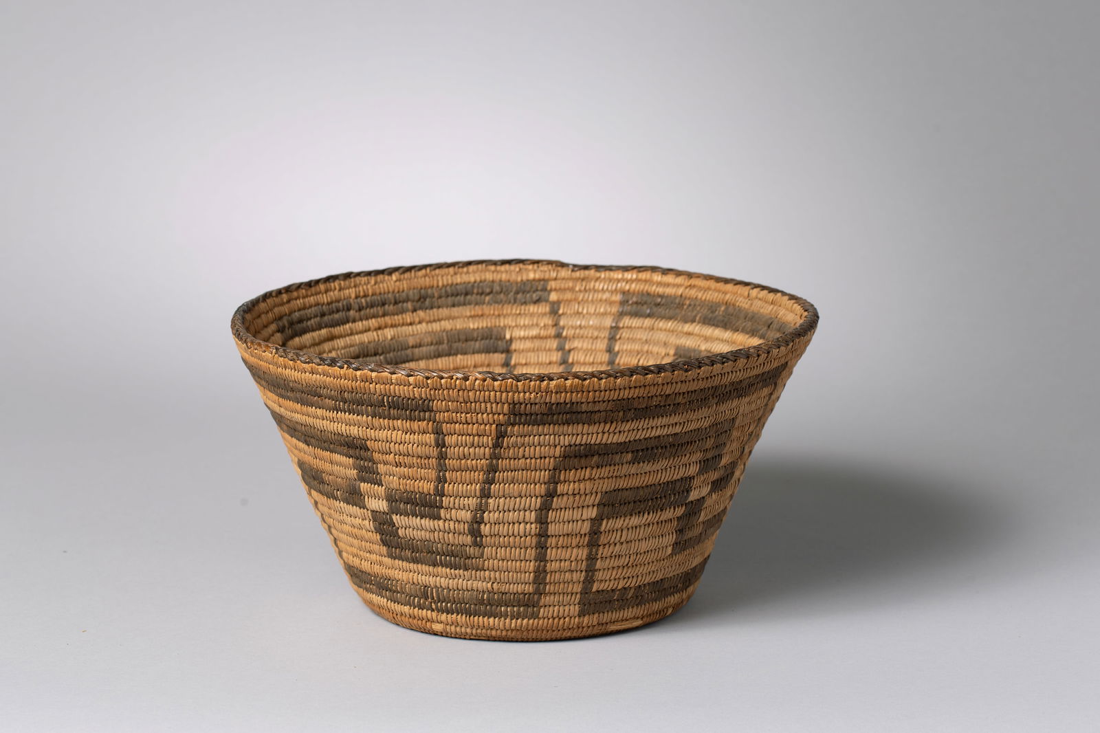 Pima Basket: Woven of willow and devil's claw, featuring a deep bowl with wide flaring sides and a maze or wheel of life design11" Diameter Top, 6.5" Base, 5.5" Height