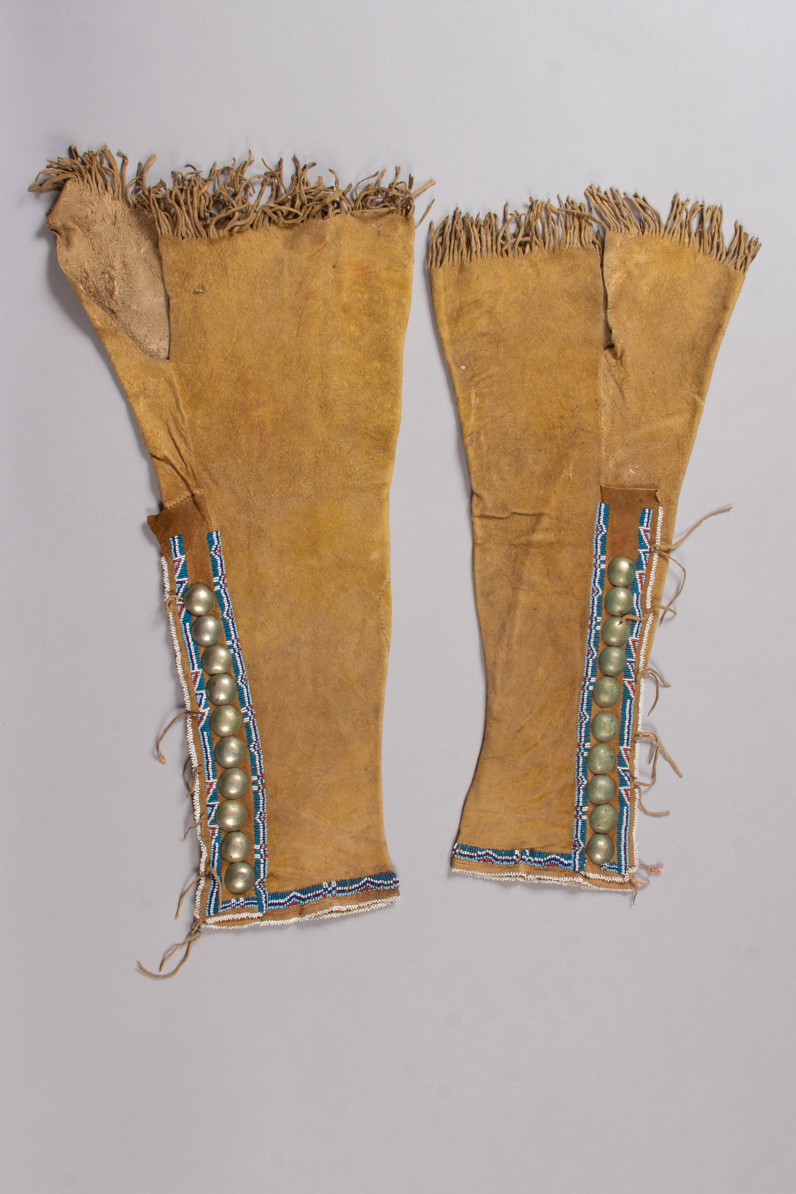 Kiowa Beaded Hide Leggings, 1890s: Pair of Kiowa Womens's Beaded Hide Leggings, with yellow pigment overall, silver buttons and classic Kiowa beading. 23" Long, Ca. 1890s