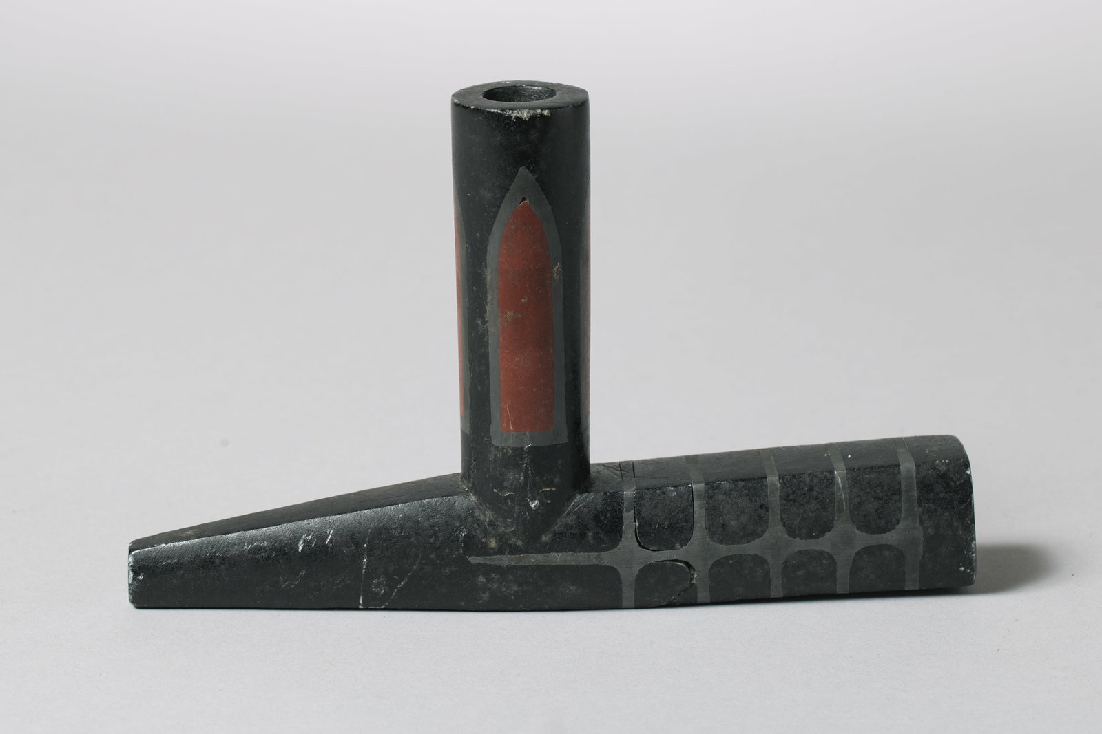 A Great Lakes Stone Pipe Bowl: Carved in traditional "T" shape, the bowl face is inset with a red pipestone panel, black and red, 8"Length, 5" Width