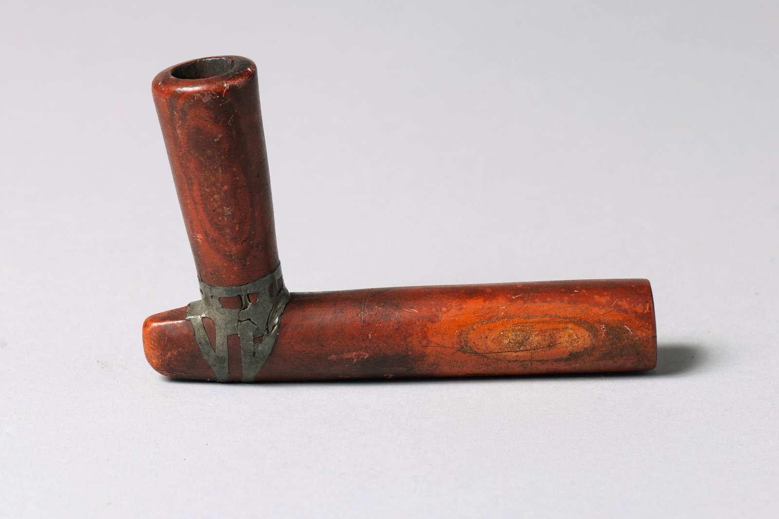 Catlinite Elbow Pipe Bowl with Lead-Inlay: Carved of deep brick-red catlinite in the classic L-shaped “elbow” form, the junction containing a traditional Native repair, 5.5" x 3"
