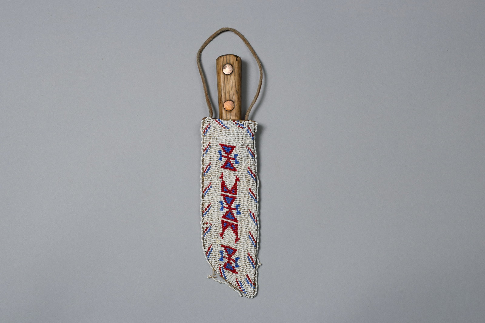Plains Beaded Knife Sheath: Deer hide sheath stitched in white, red, and blue seed beads, decorated with classic stepped geometric motifs and diagonal bar accents; fitted with a simple wood-handled knife6" Blade, 7.75" Sheath Le