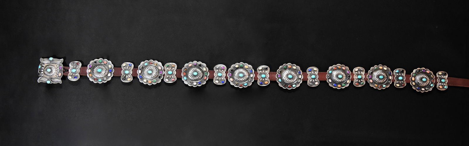 Multi Color Stone Concho Belt: Eight conchos each measuring 2 1/8" width, 2 1/4" height with 12 different colored stones on outer rim of concho and a turquoise cabachon in center; Nine butterfly conchos each measuring 1 1/4" x 1" w
