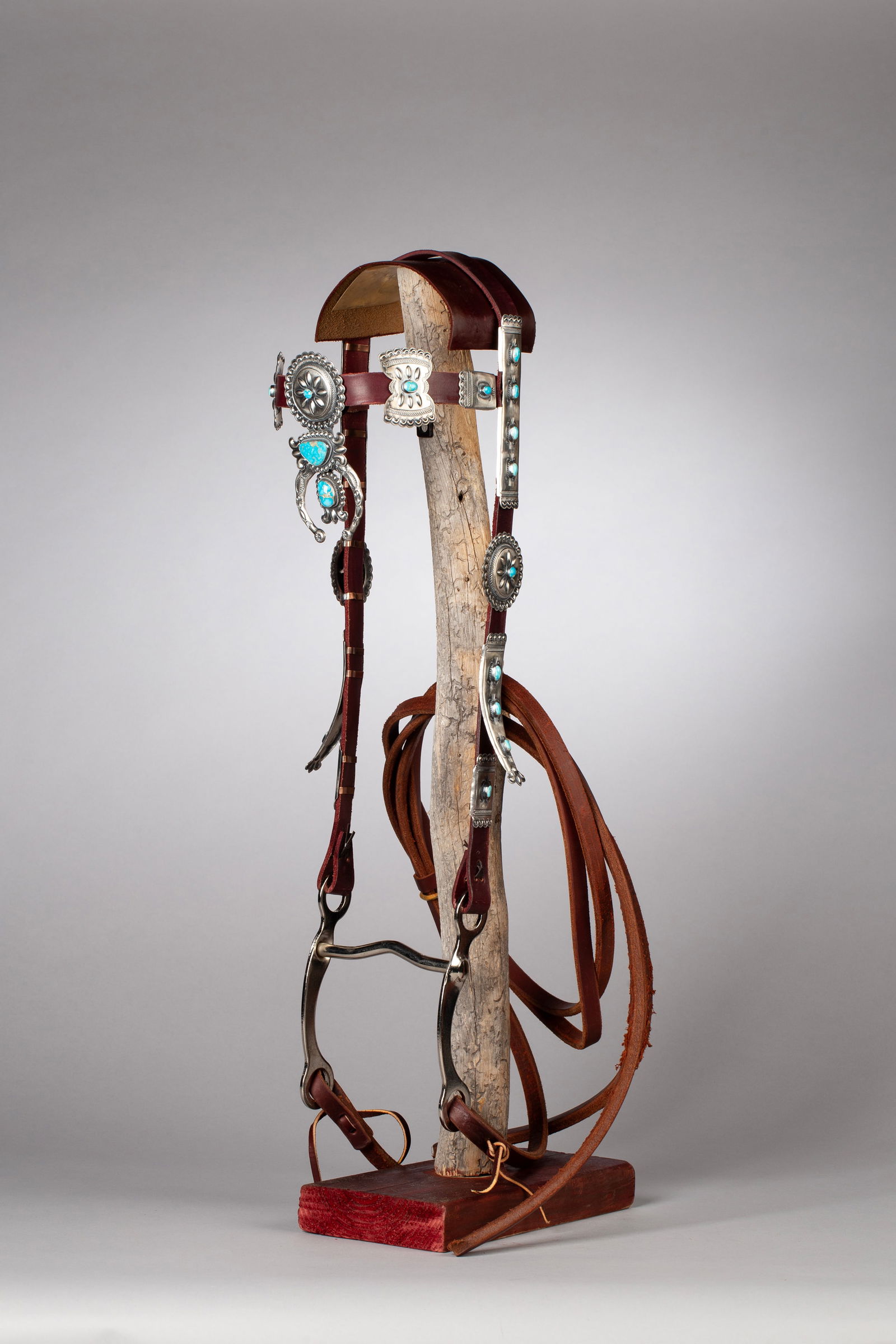 Stunning Contemporary Navajo Bridle by Robert Johnson, Award Winning Artist with Custom Stand: Contemporary Navajo made Bridle is accented with 25 pieces of Blue Ridge turquoise, cut from one large stone. One piece silver naja with Blue Ridge Turquoise. Handstamped sterling silver bars and larg