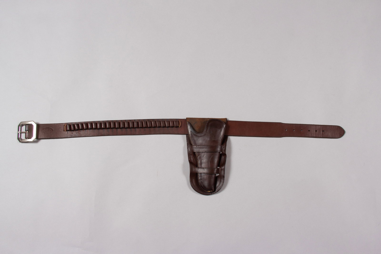 Museum Quality Miles City Saddlery Gun Rig: Marked "MILES CITY SADDLERY CO, MILES CITY, MONT." on both belt and holster. Belt has marked silver buckle and loops to accommodate 25 cartridges. Belt measures 42".