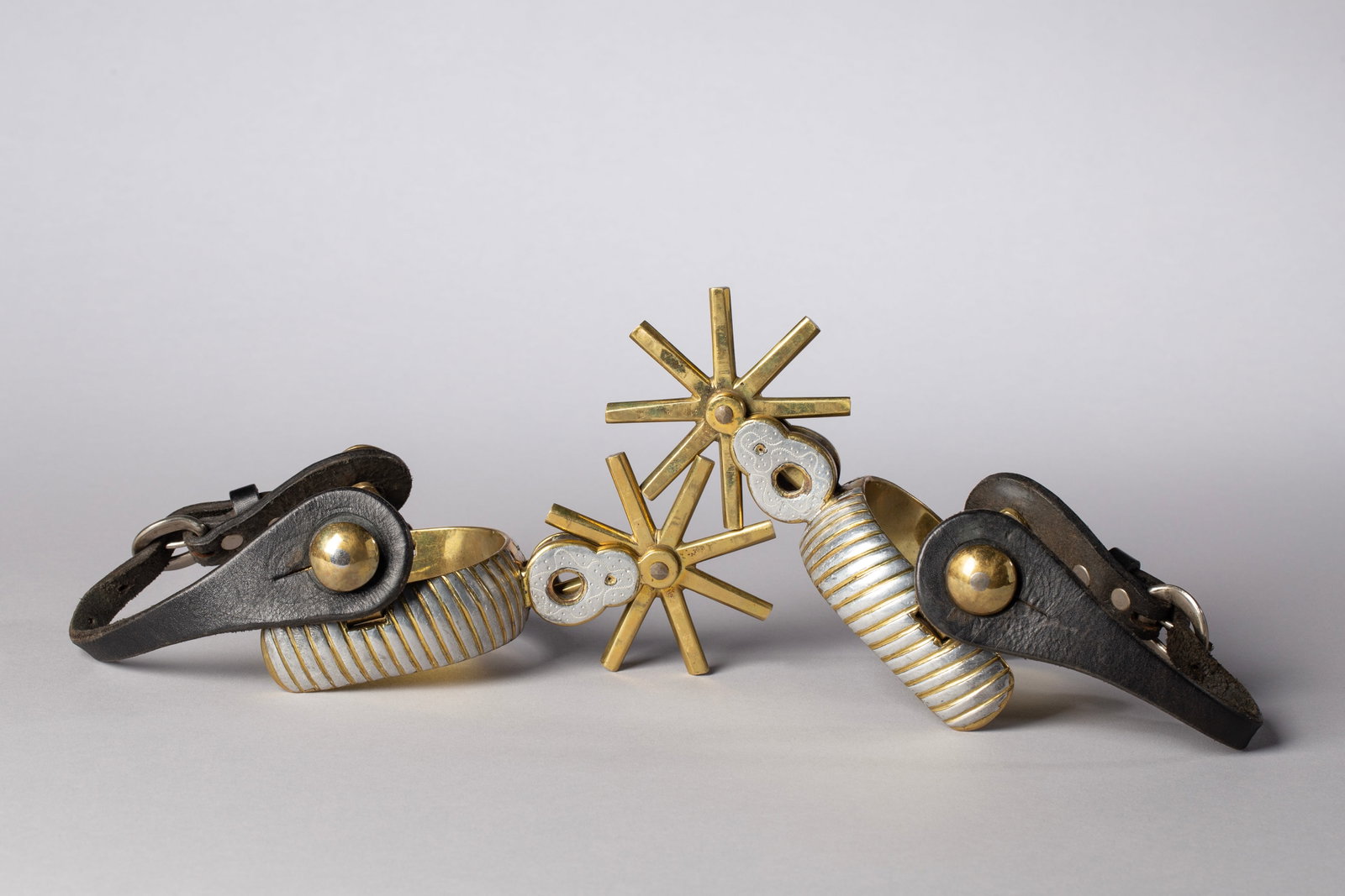 Mid Century Gold and Silver Mexican Spurs: Gold with silver inlay on heel band, shank and rowel. Nice age-appropriate leather straps. Heel opening 3"heel width 1 1/8"rowel diameter 3"8 point rowel