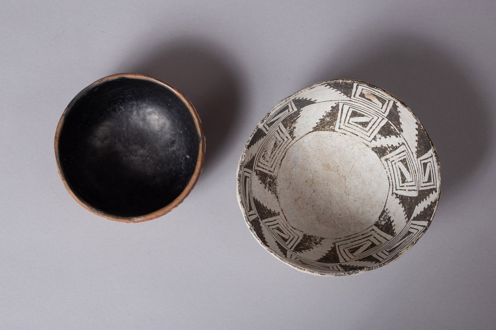 Interesting Intact Group of Anasazi Bowls, Ca 1100 - 1350 AD: Group of Two Pots: A) Corrugated Redware Bowl 4 3/8"D, 2"H B) Red Mesa Black and White Bowl with 2 holes aligned across 1/2" from top 5 3/4"D, 2 3/4"H Provenance: Major & Nan Spessard Collection