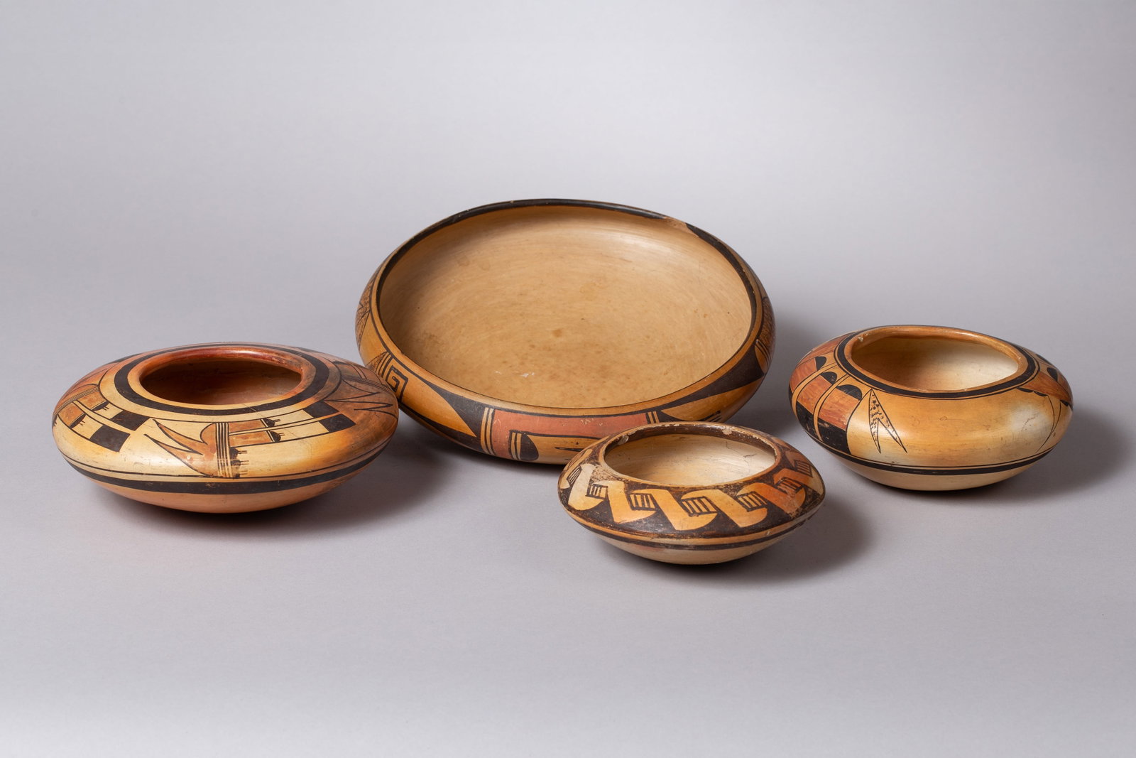 Group of Four Hopi Redware Polychrome Bowls: A beautiful and well-proportioned set of four handmade Hopi redware pottery bowls, each featuring distinct polychrome designs. Crafted with traditional coiling methods, these bowls exhibit the rich, e