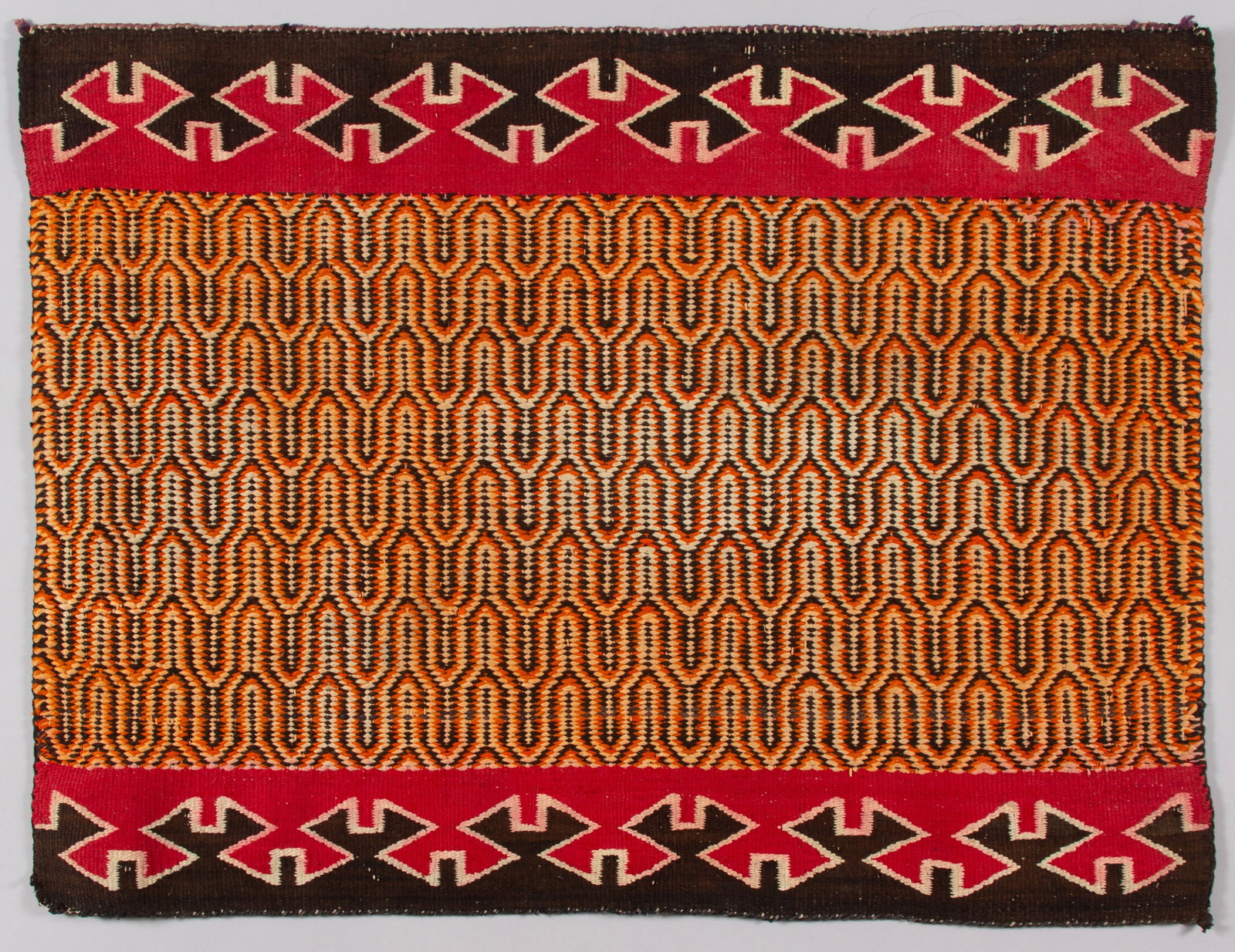 Rare Navajo Single Saddle Blanket, Early 20th Century: A fine example of Native American weaving, this single saddle blanket features a striking central panel woven in a complex twill weave pattern using hand-spun wool. The dynamic, repeating geometric de