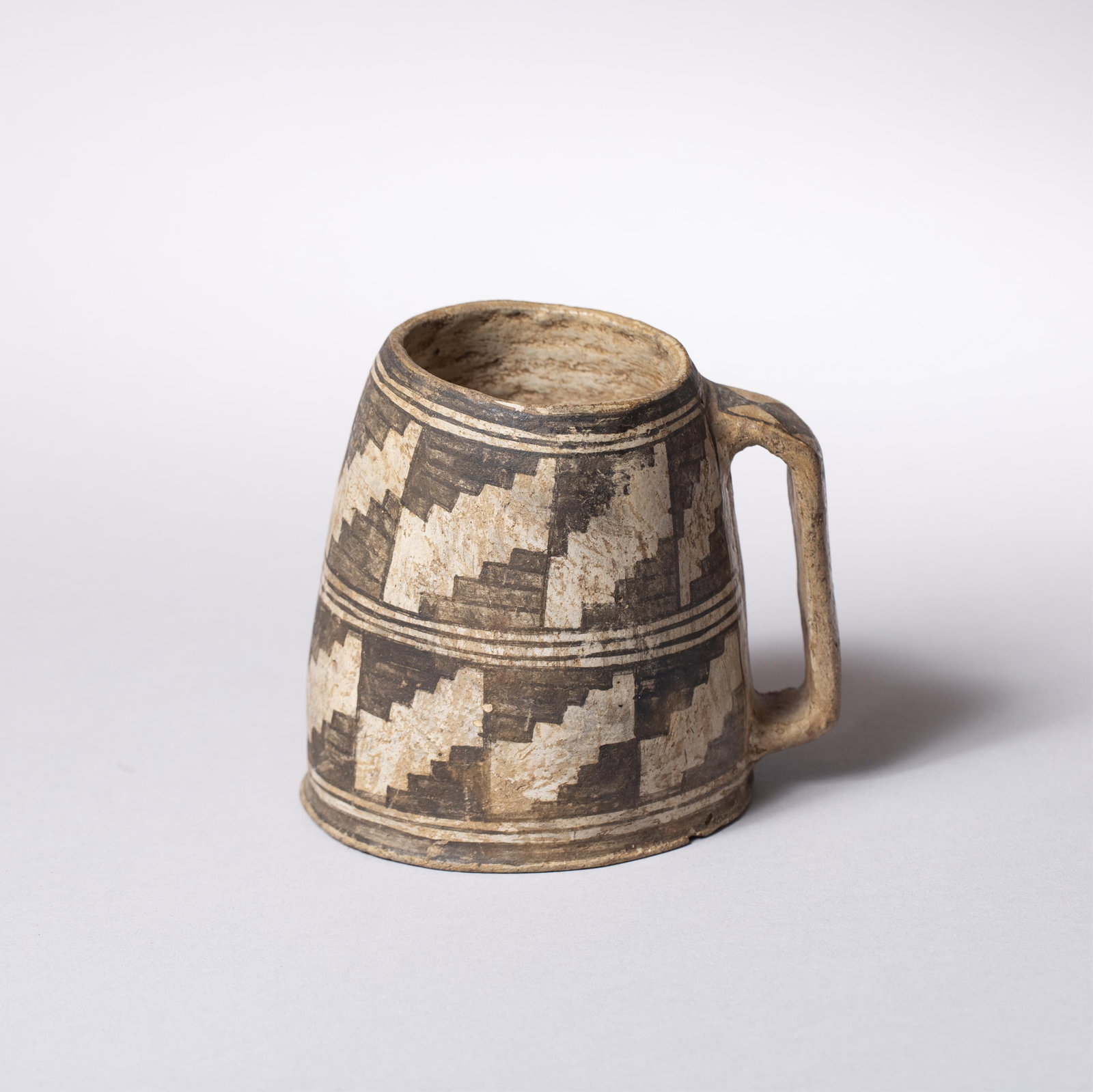 Mesa Verde Mug, 4 1/2 x 5 in. (11.4 x 12.7 cm.): Mesa Verde mug with stair-step like design around the outside of the mug. Faint diamond like pattern on the handle. Ca. 1100 AD