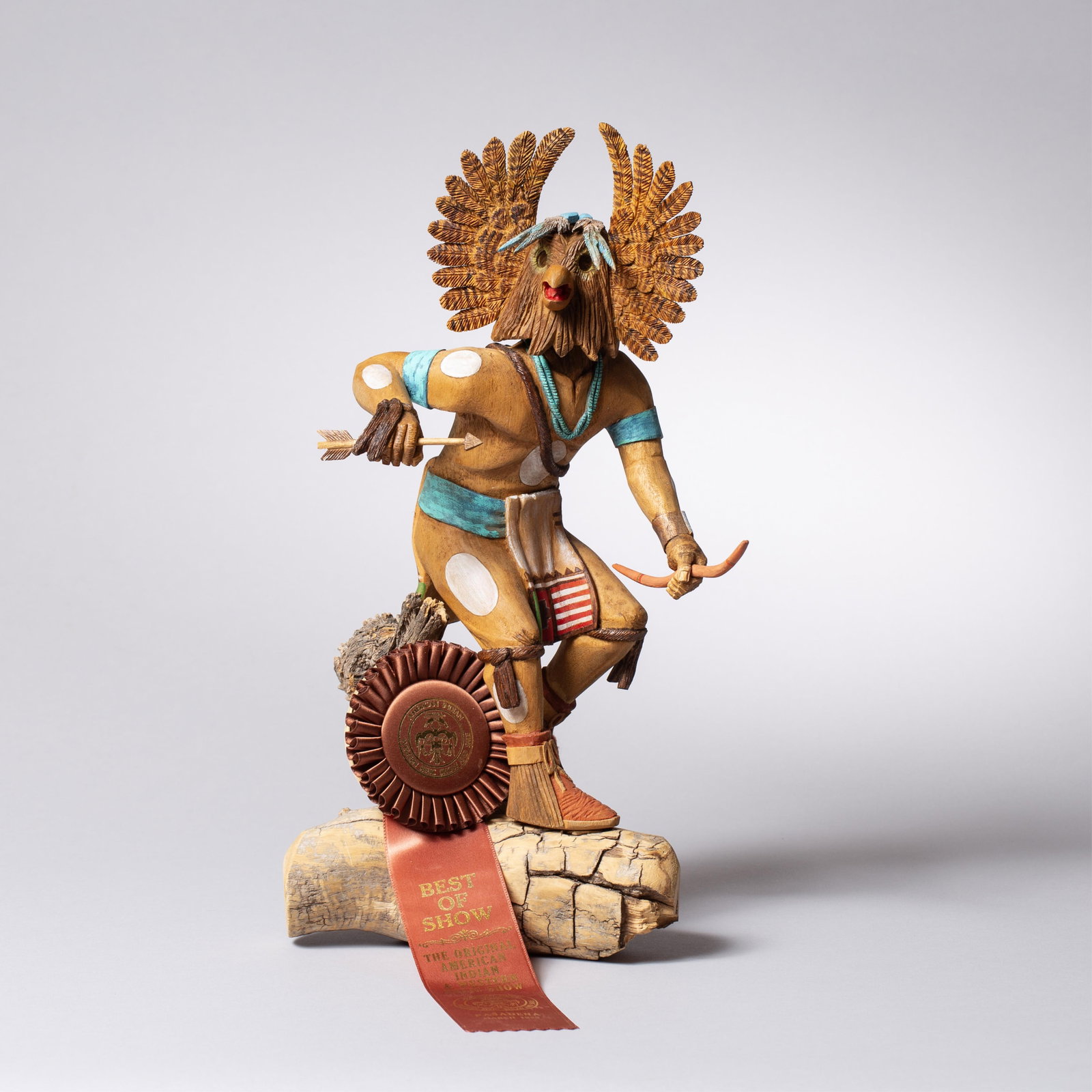 Best of Show Wood Owl Katsina, Ernest Honanie: Carved wood Owl Katsina by Ernest Honanie, depicting a standing figure with radiating owl headdress and stylized features, including a beaked mouth and carved facial detailing. Painted in naturalistic