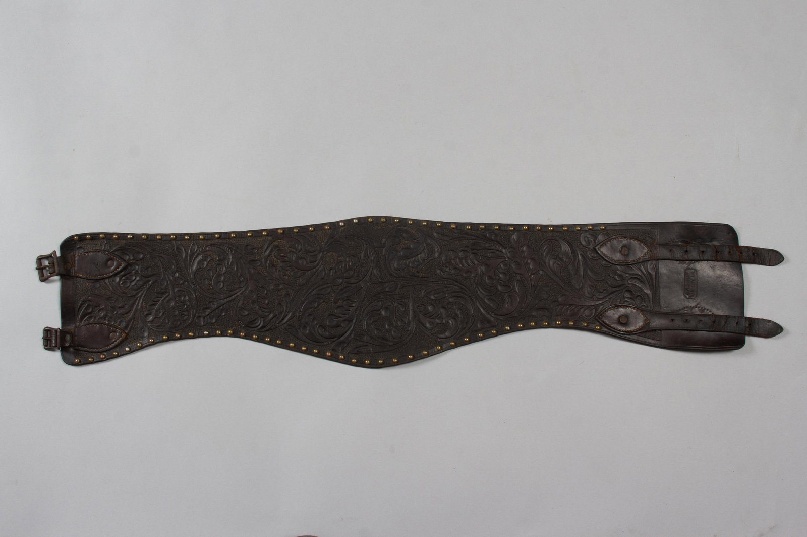 C.P. Shipley Floral tooled Bronc Belt: Marked "C.P. SHIPLEY, KAN. CITY, MO.". Deep dark brown leather with floral tooling and lined with brass tacks. 35"Long