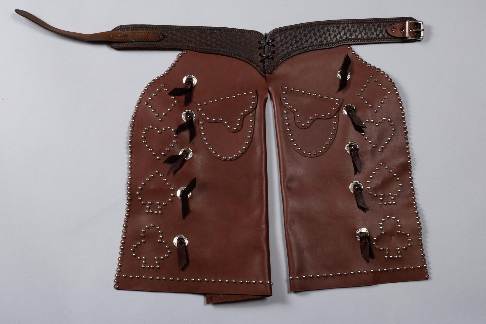 Kid's Card Suit Chaps, Marked Jerry Dyck, Oregon: Kids Card Suit Chaps. A fancy set of kid's Card suit studded leather bat wing style chaps with floral tooling on belt and marked "Jerry Dyck, Prineville, Ore". The waist is 27". 20"L