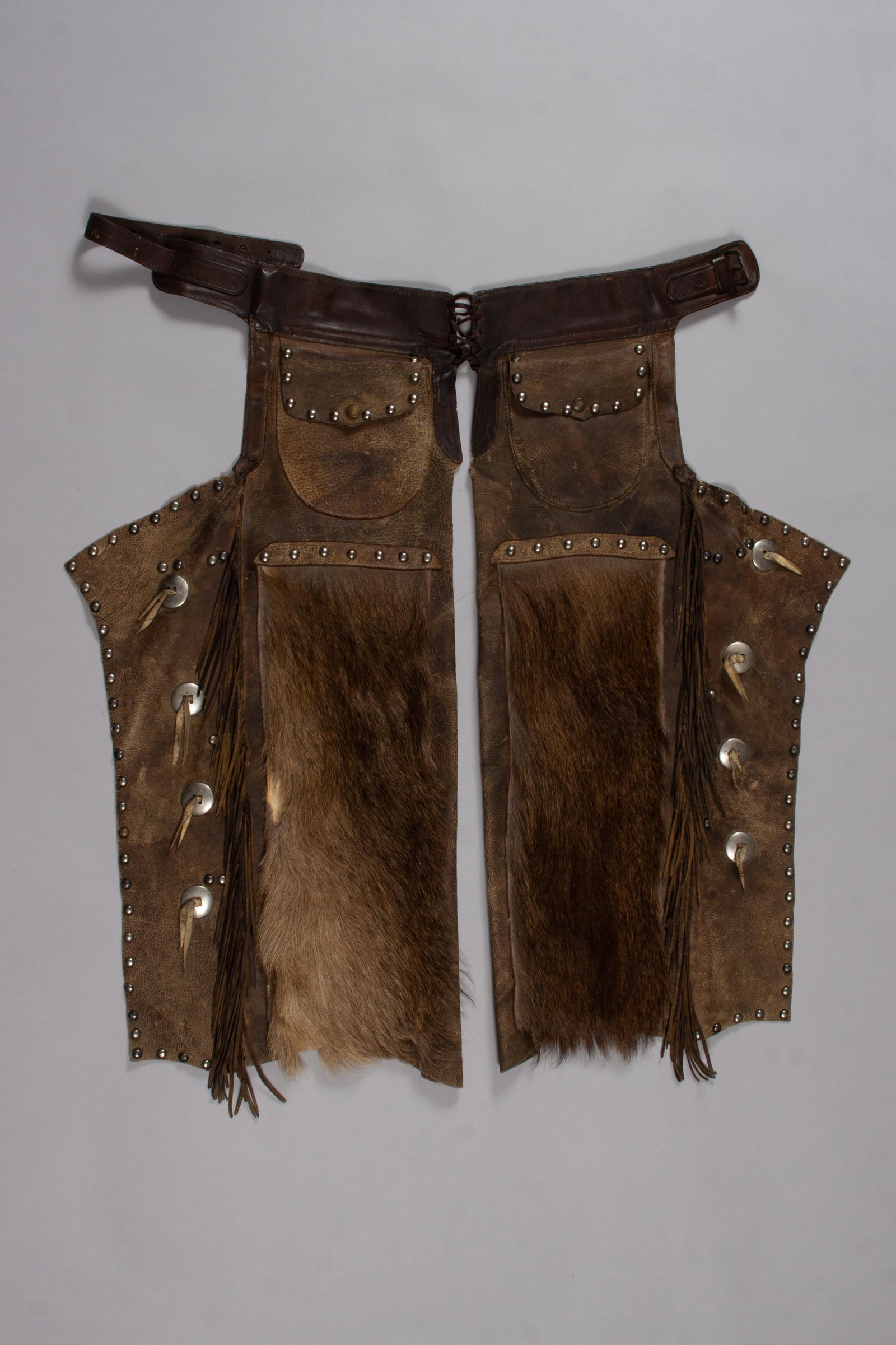 Vintage John Clark Saddlery Co. Chaps with Elk Hair, Portland, OR: A wonderful pair of chaps from Clark Saddlery Co. in Portland Oregon. Marked "Clark" on the belt, these chaps feature a dark brown leather belt and upper leg sections with silver studs and conchos. A