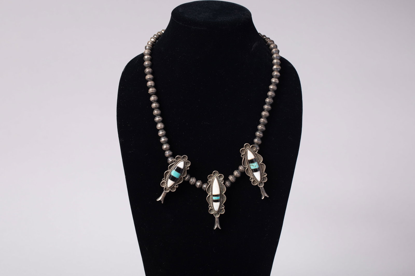 Vintage Zuni Multi-Stone Inlay and Sterling Silver Choker Necklace: Vintage Native American Zuni choker necklace featuring a triple-pendant design seamlessly integrated into a strand of polished sterling silver bench beads. Each of the three elongated pendant panels s