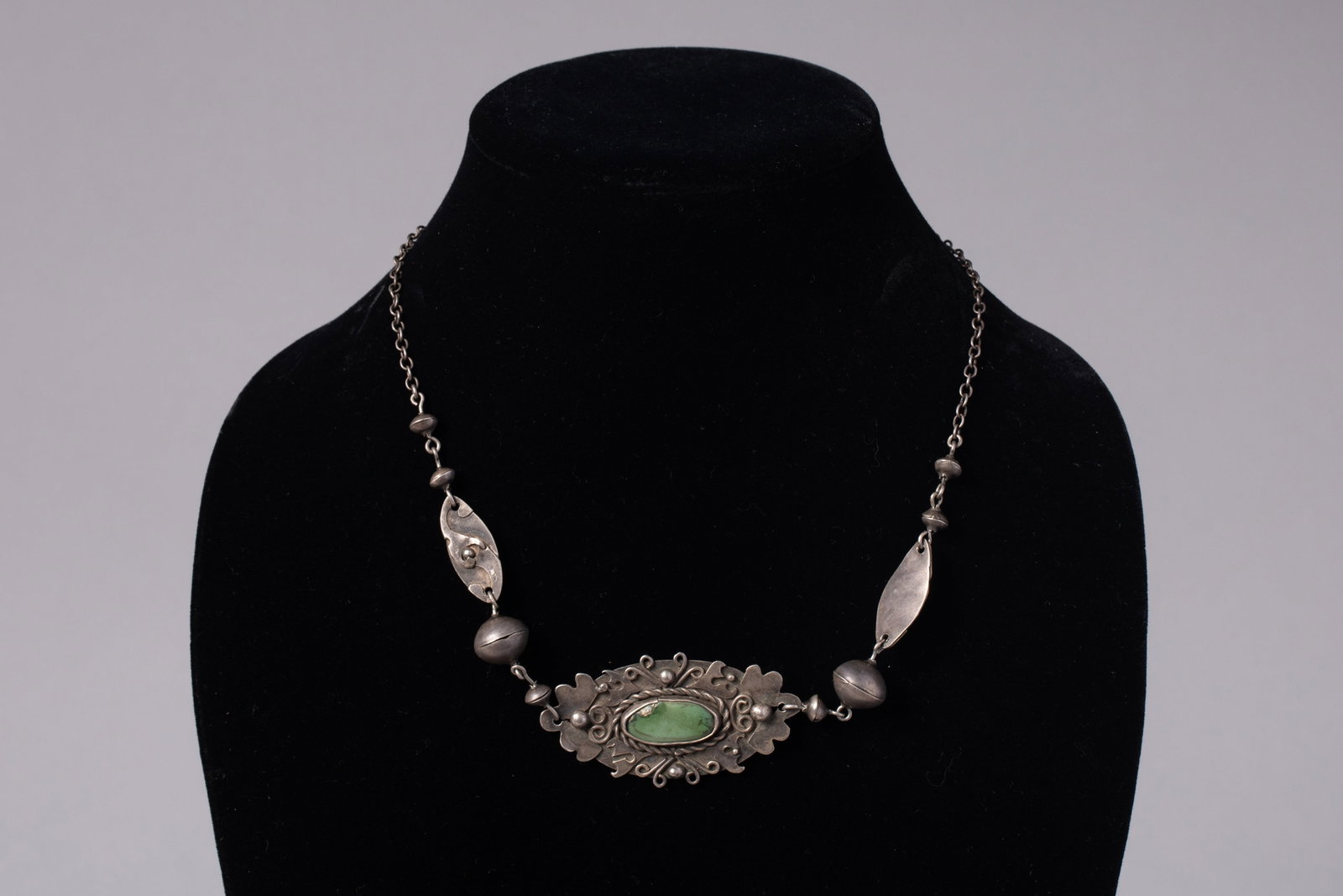Vintage Native American Pueblo Silver and Green Turquoise Dainty Link Necklace: The central setting features an oval-shaped, light-green turquoise cabochon bezel set within an ornate, stamped silver border.Hangs: 7.75 in.