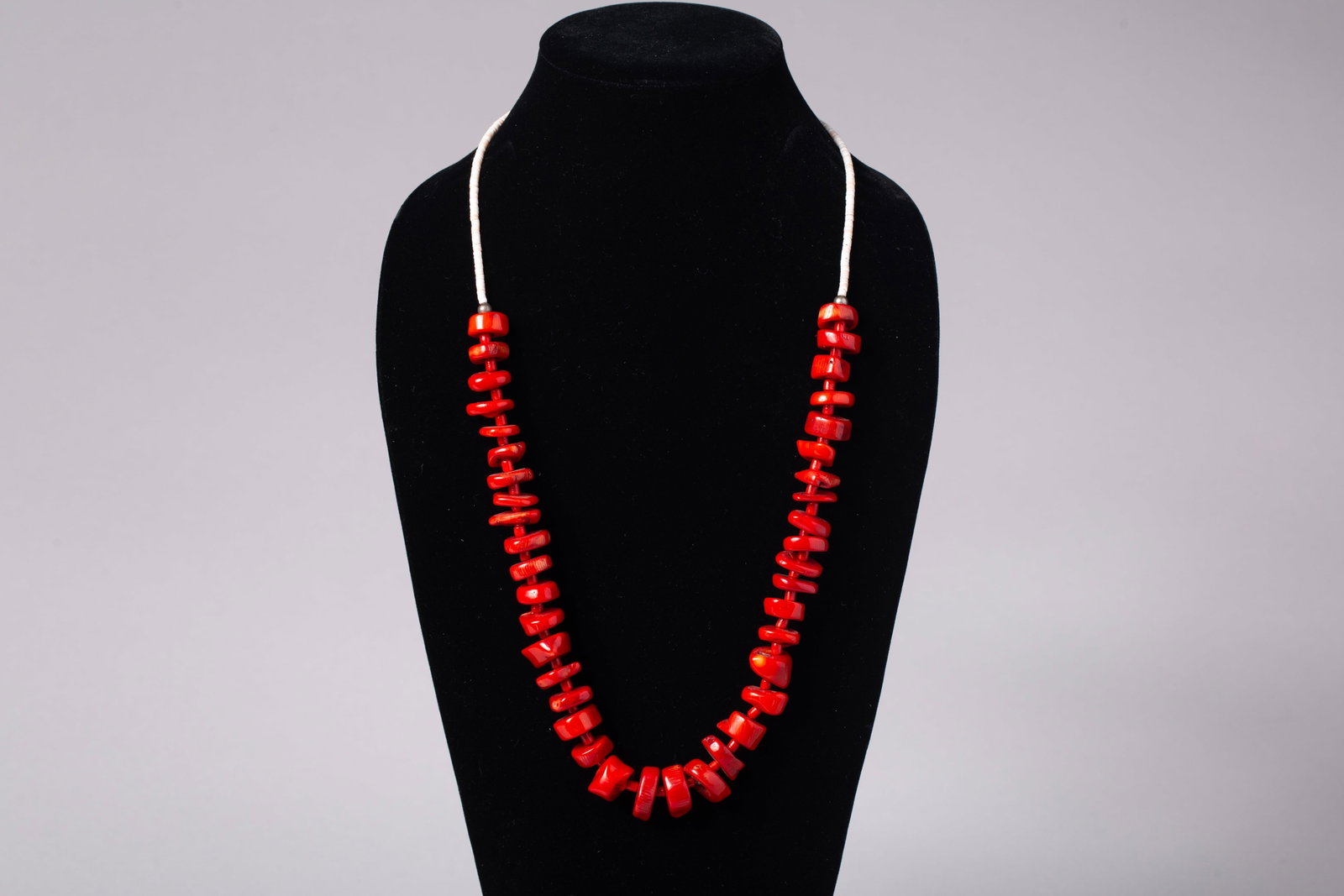 Santo Domingo (Kewa Pueblo) Single-Strand Red Coral Heishi and Nugget Necklace: Santo Domingo coral bead and nugget necklace, strung with graduated red coral disc beads and irregular coral nuggets, arranged in a tapered form with larger polished nuggets toward the center.