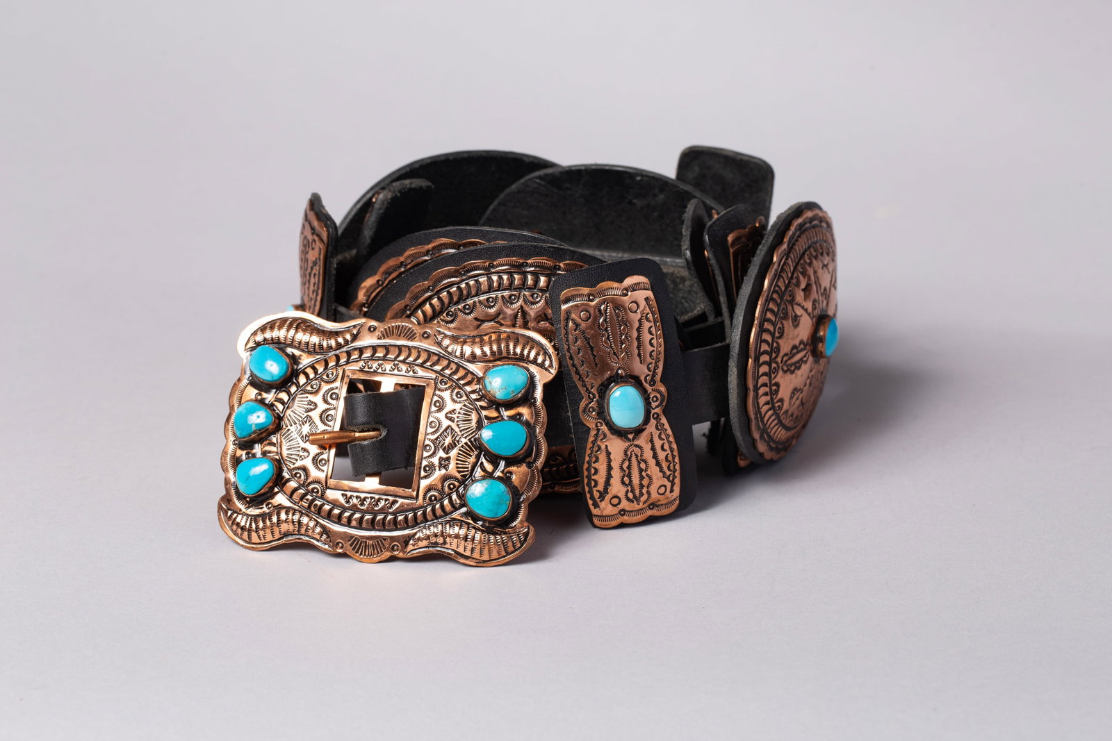 Native American Style Turquoise and Copper Concho Belt: This striking Southwest-style concho belt blends rugged craftsmanship with traditional design. It features beautifully detailed metalwork accented by vibrant blue turquoise stones. The piece makes a b