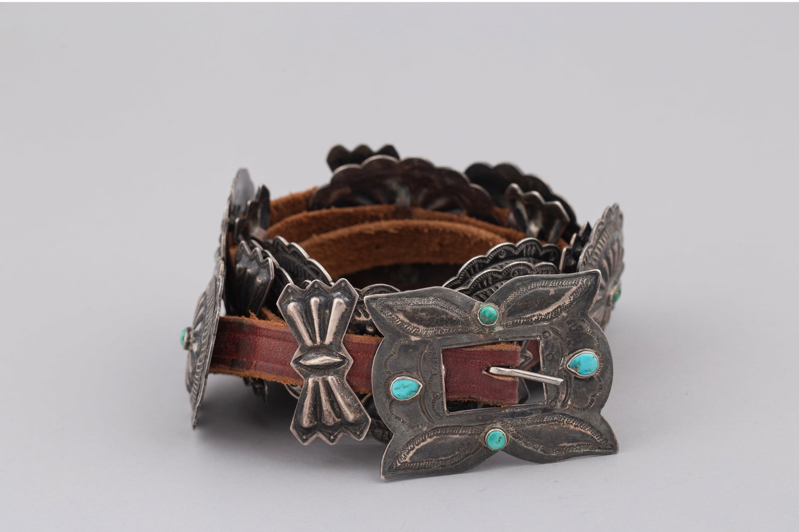 Concha belt Four Cabachons on buckle, ca 1920-30s: An exceptional and highly collectible vintage Navajo (Diné) silver concho belt mounted on a thick, dark leather strap. Reflecting classic mid-to-late 20th-century Native American artistry.Eleven oval